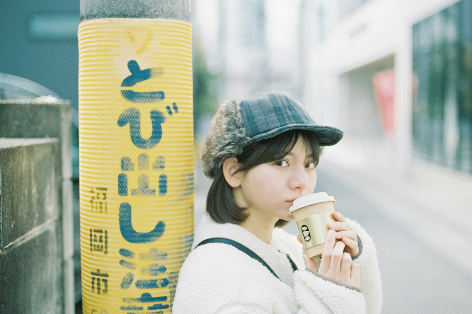 在街道标志前拿着咖啡的女性肖像