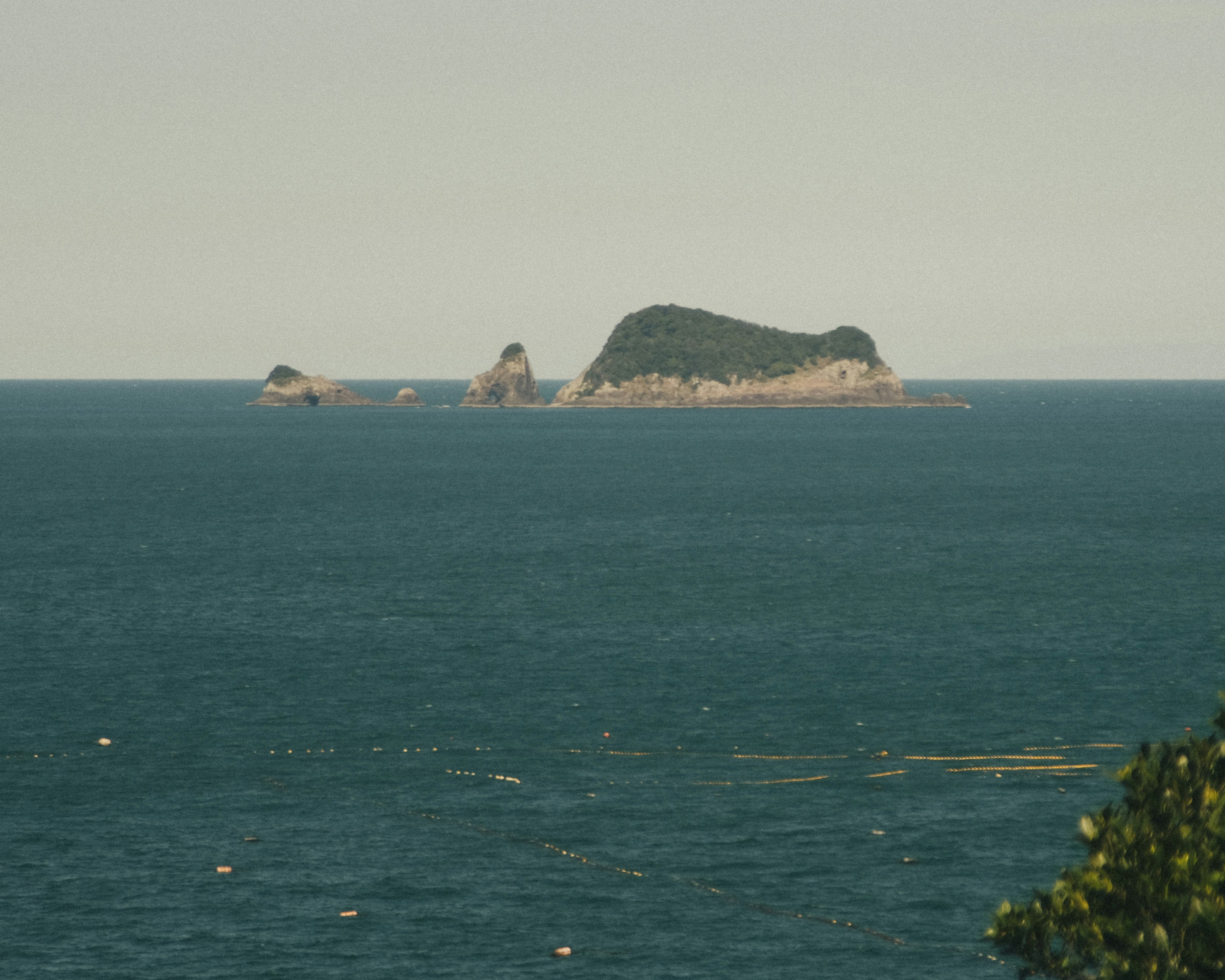 海上に浮かぶ小島と岩礁のある水平線の風景
