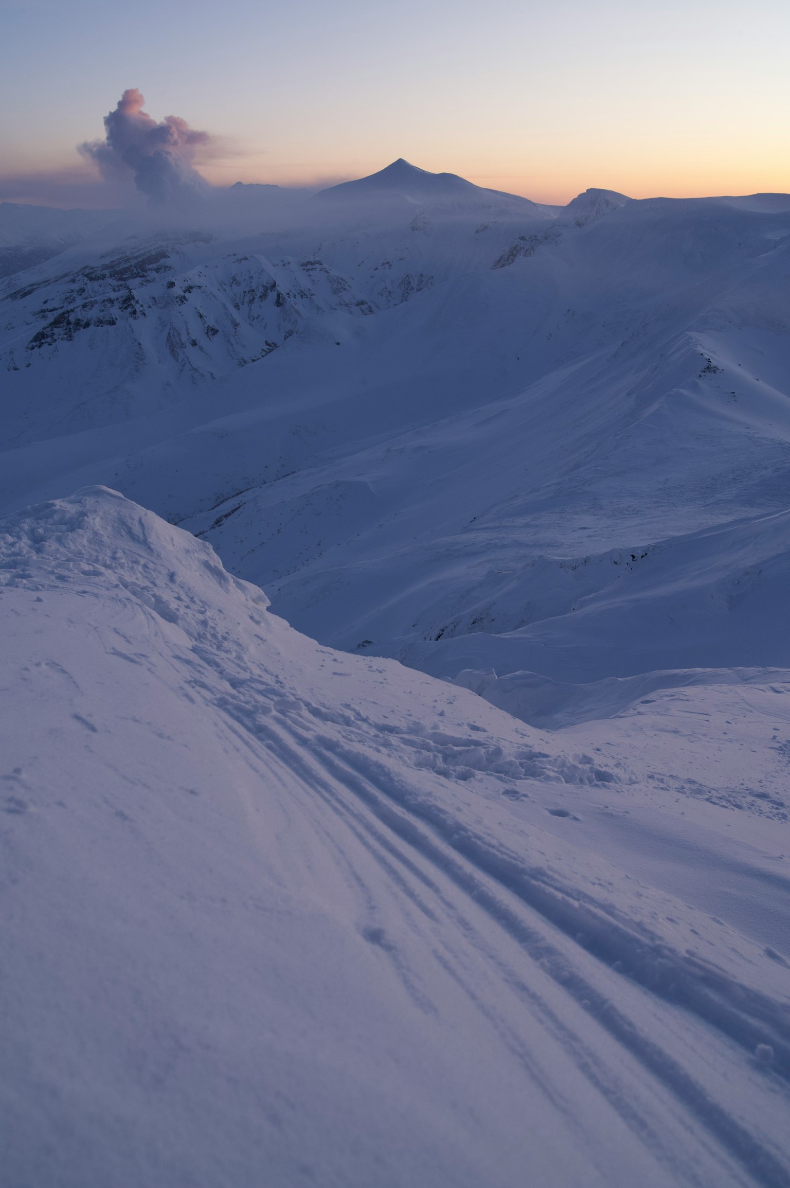 Paesaggio montano coperto di neve con cielo al tramonto