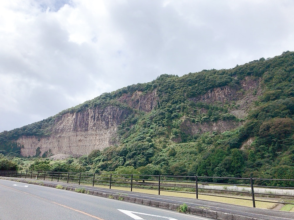 山腹の緑に囲まれた道路と防護柵のある風景
