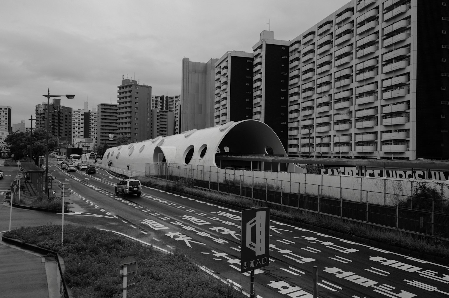 Tunnel de circulation futuriste et gratte-ciels dans un paysage urbain en noir et blanc