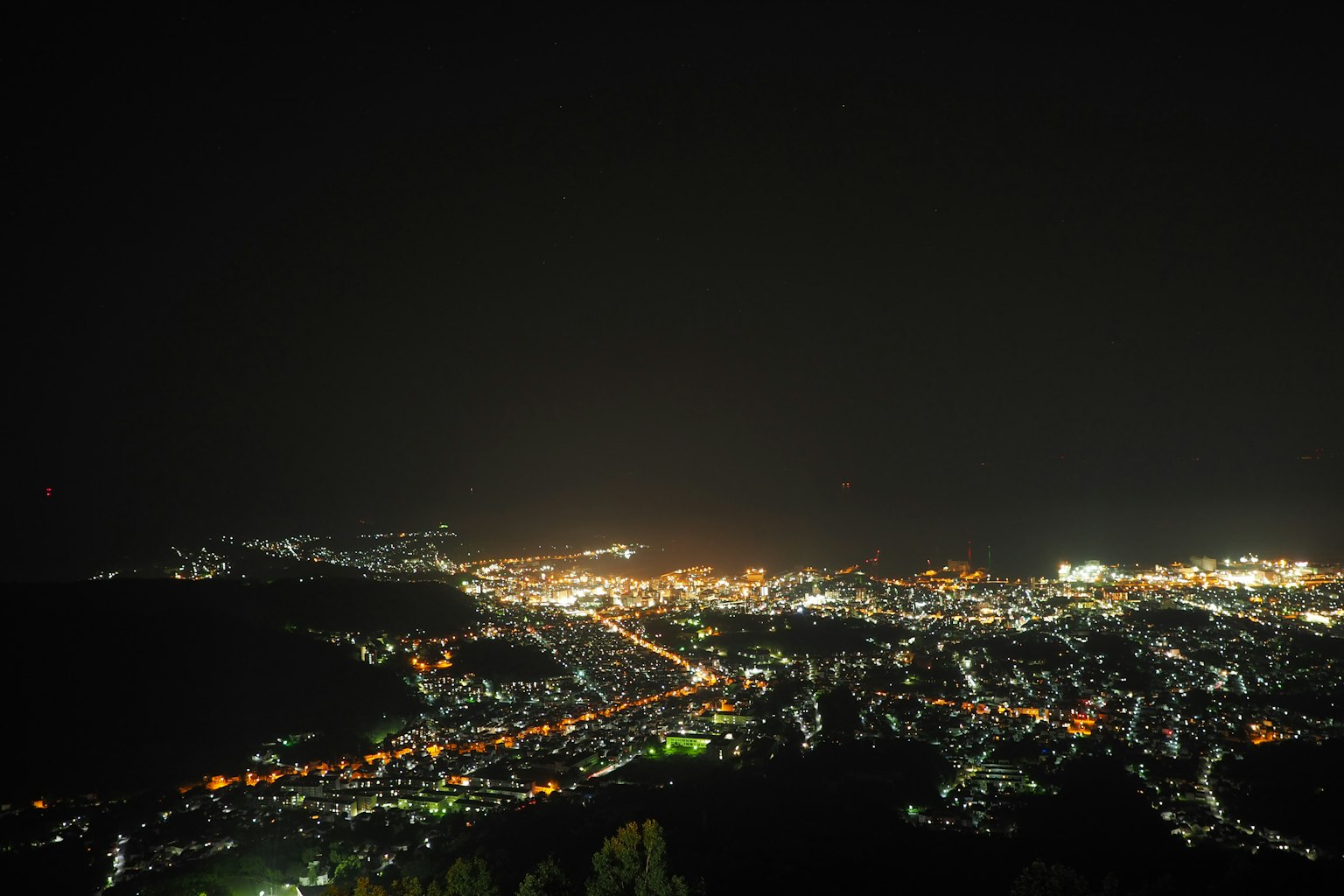 ทิวทัศน์เมืองกว้างใหญ่ในตอนกลางคืนพร้อมไฟถนนสว่าง