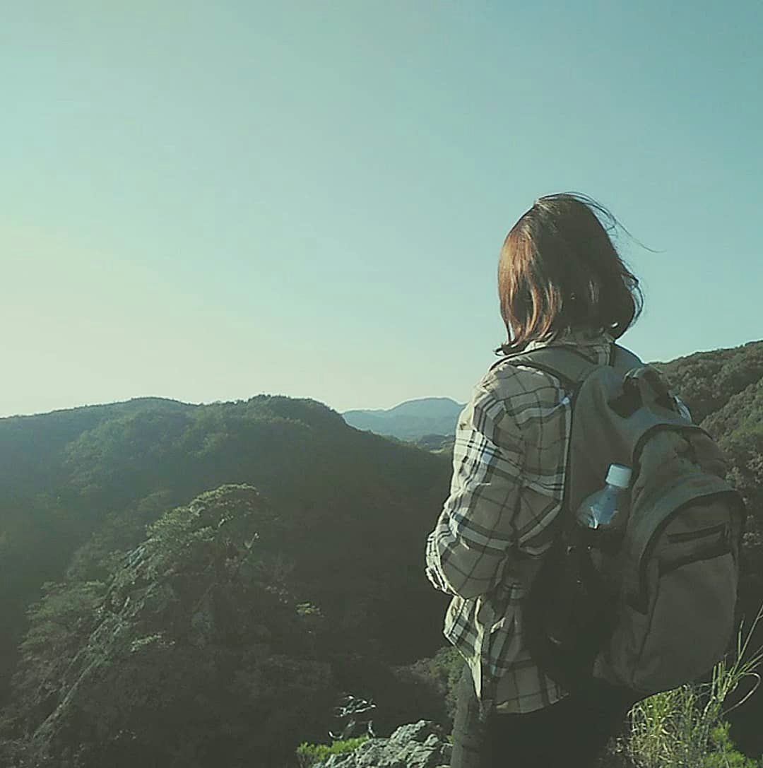 兵庫県神戸市北区の百丈岩を望む山の稜線で立つ登山者の後ろ姿