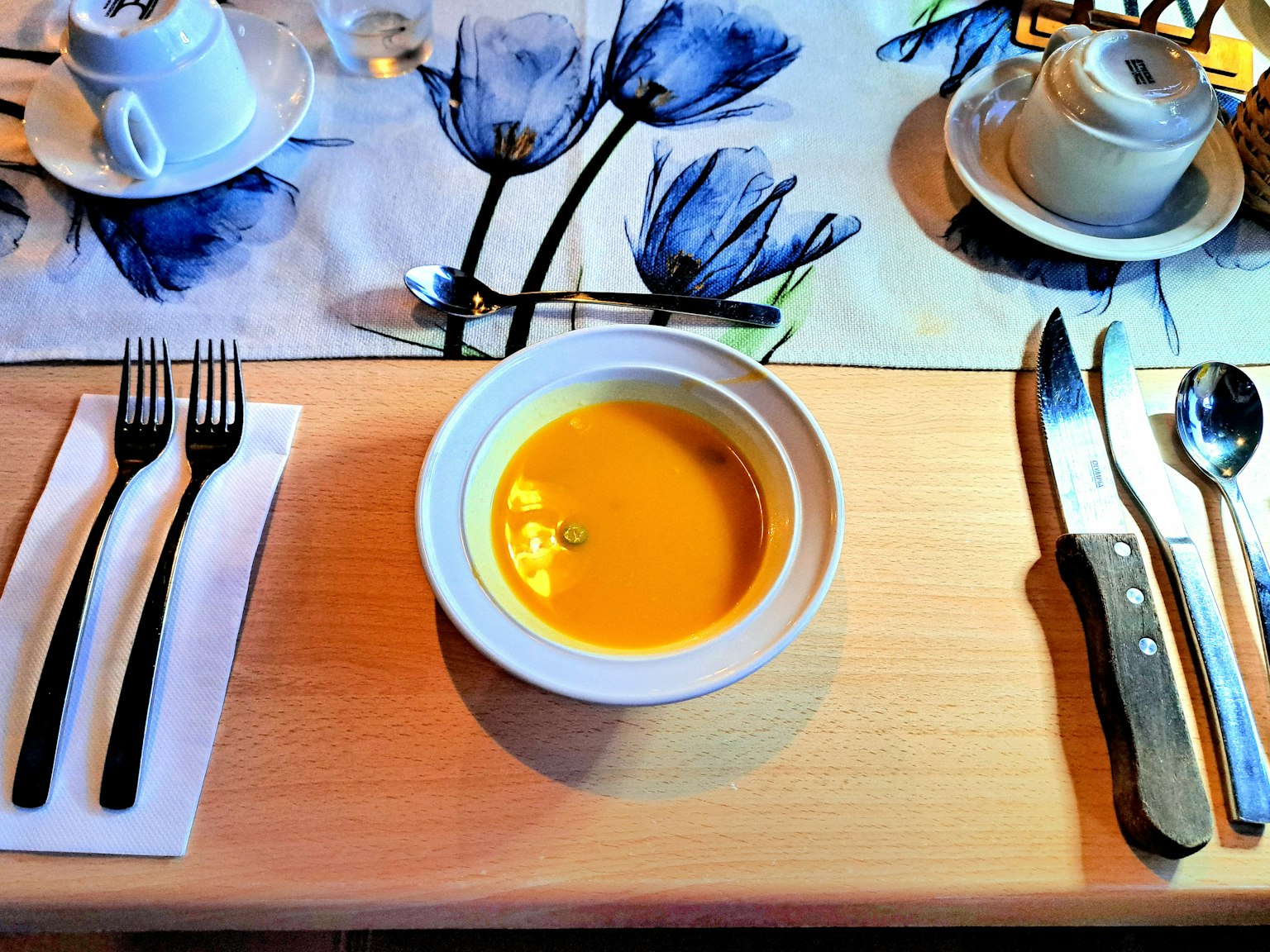 Tischdekoration mit einer Schüssel Cremesuppe und Besteck
