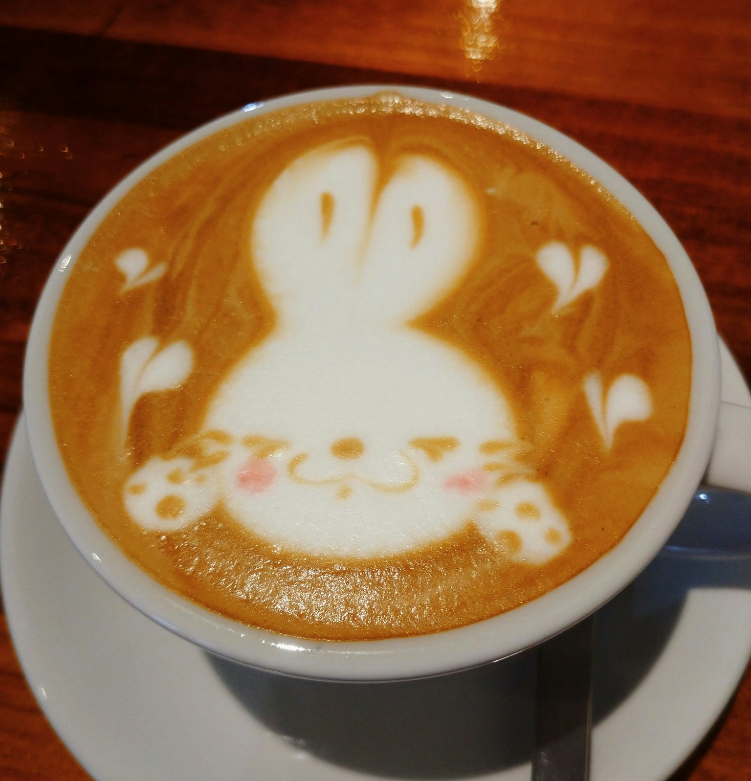 Latte art featuring a rabbit face in a coffee cup
