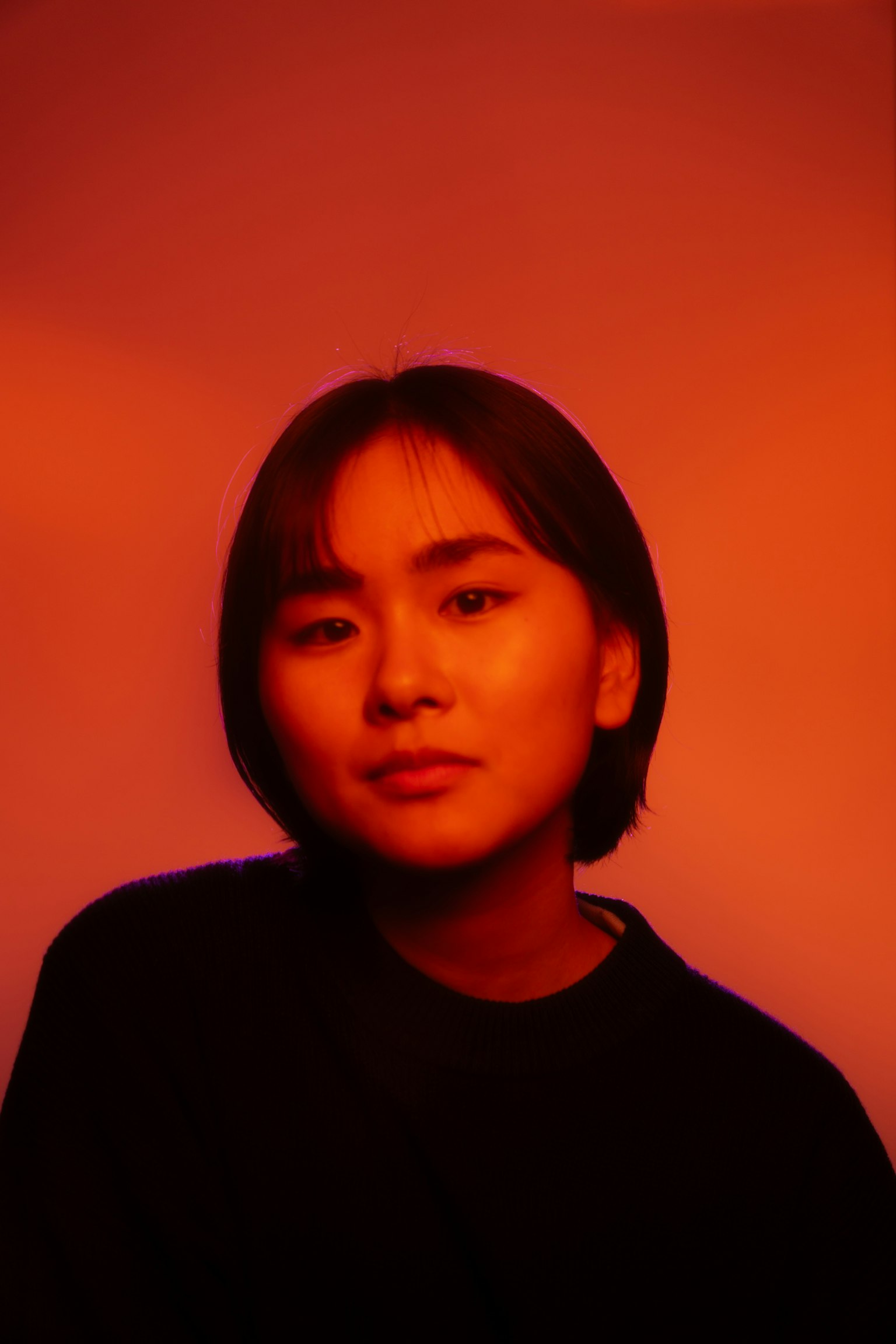 短髮女性在紅色背景前的肖像