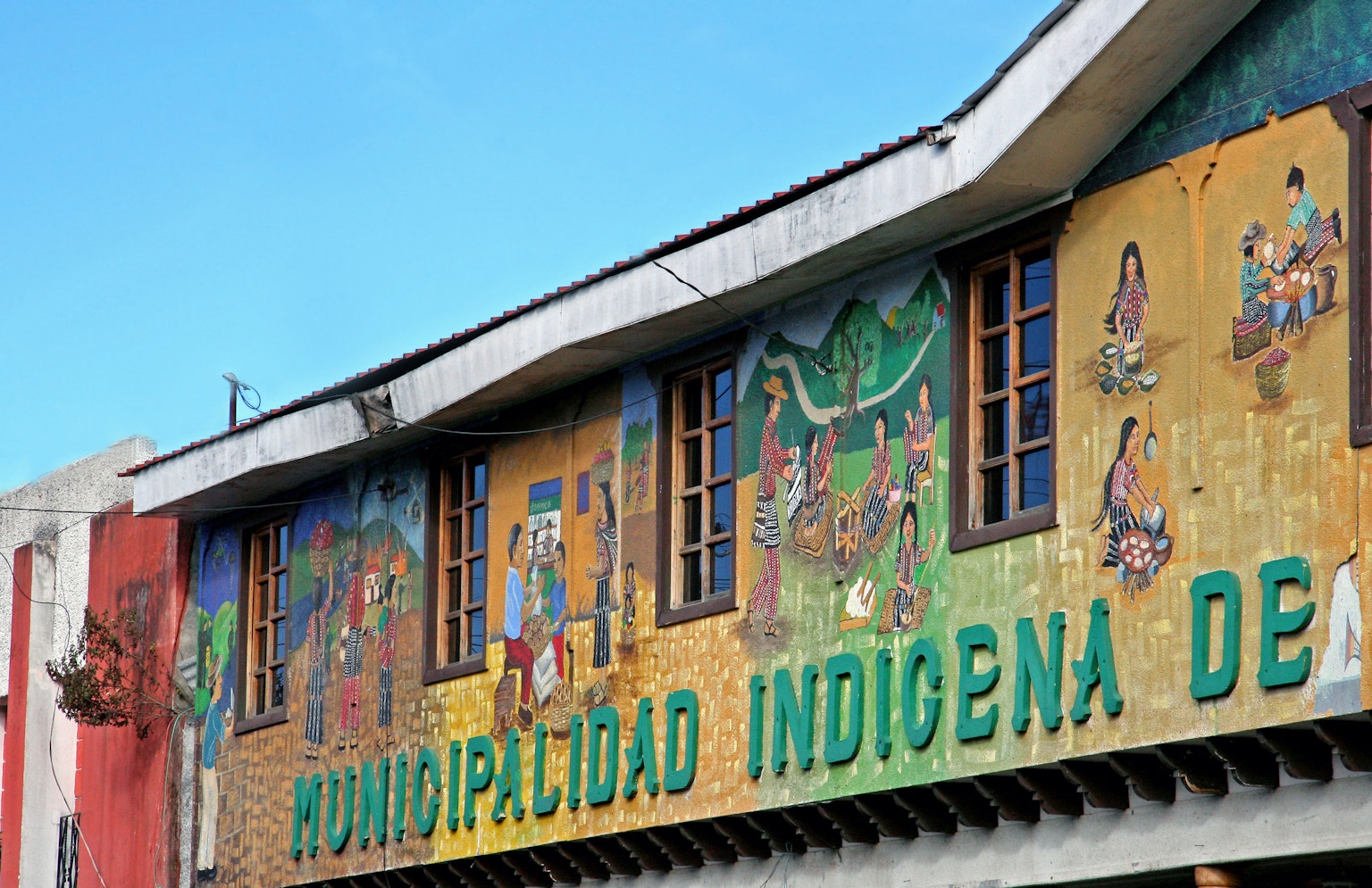 Eksterior gedung pemerintah adat dengan mural berwarna-warni