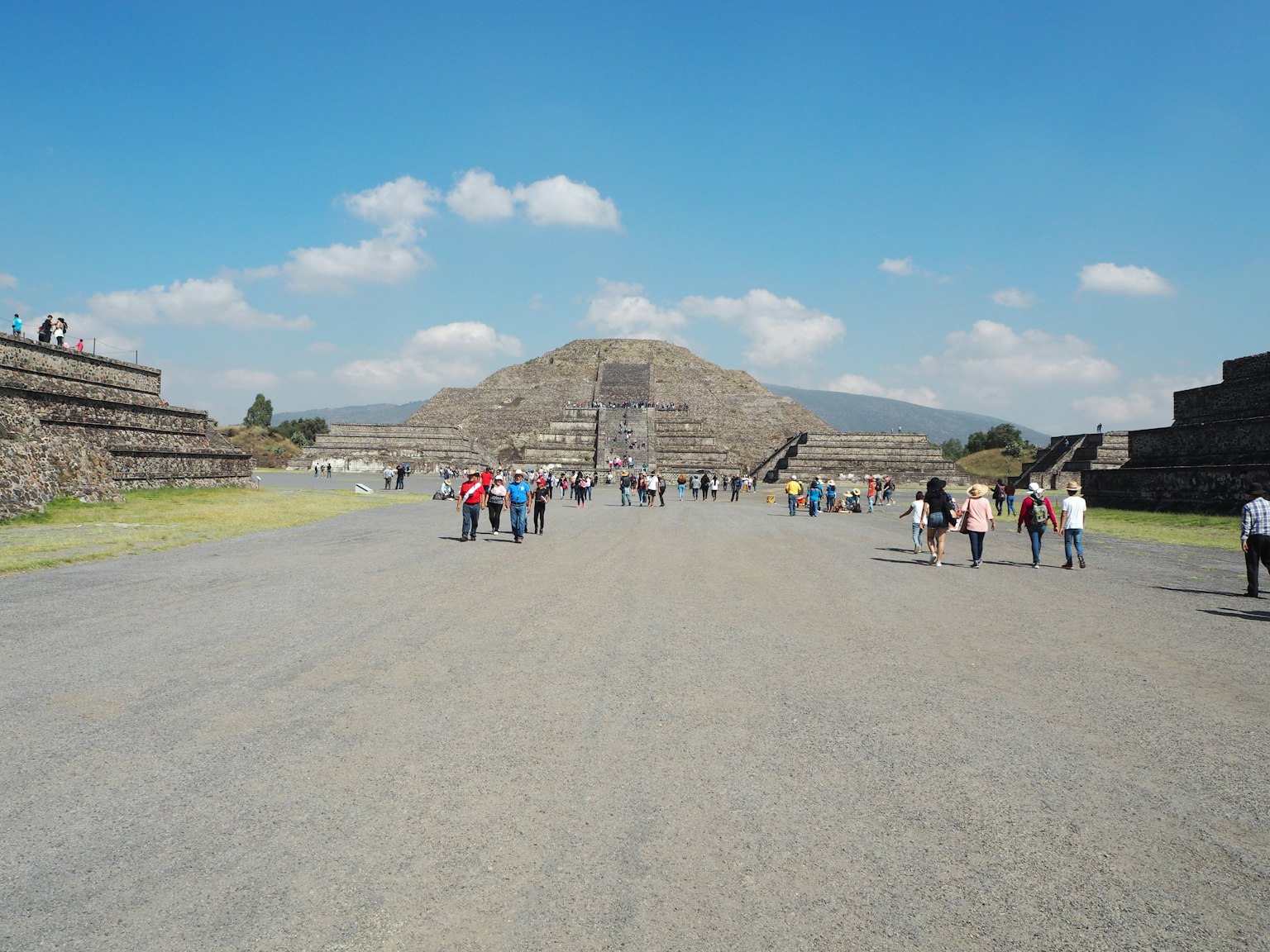 Du khách đi dọc theo con đường rộng với Kim tự tháp Mặt Trời ở Teotihuacan