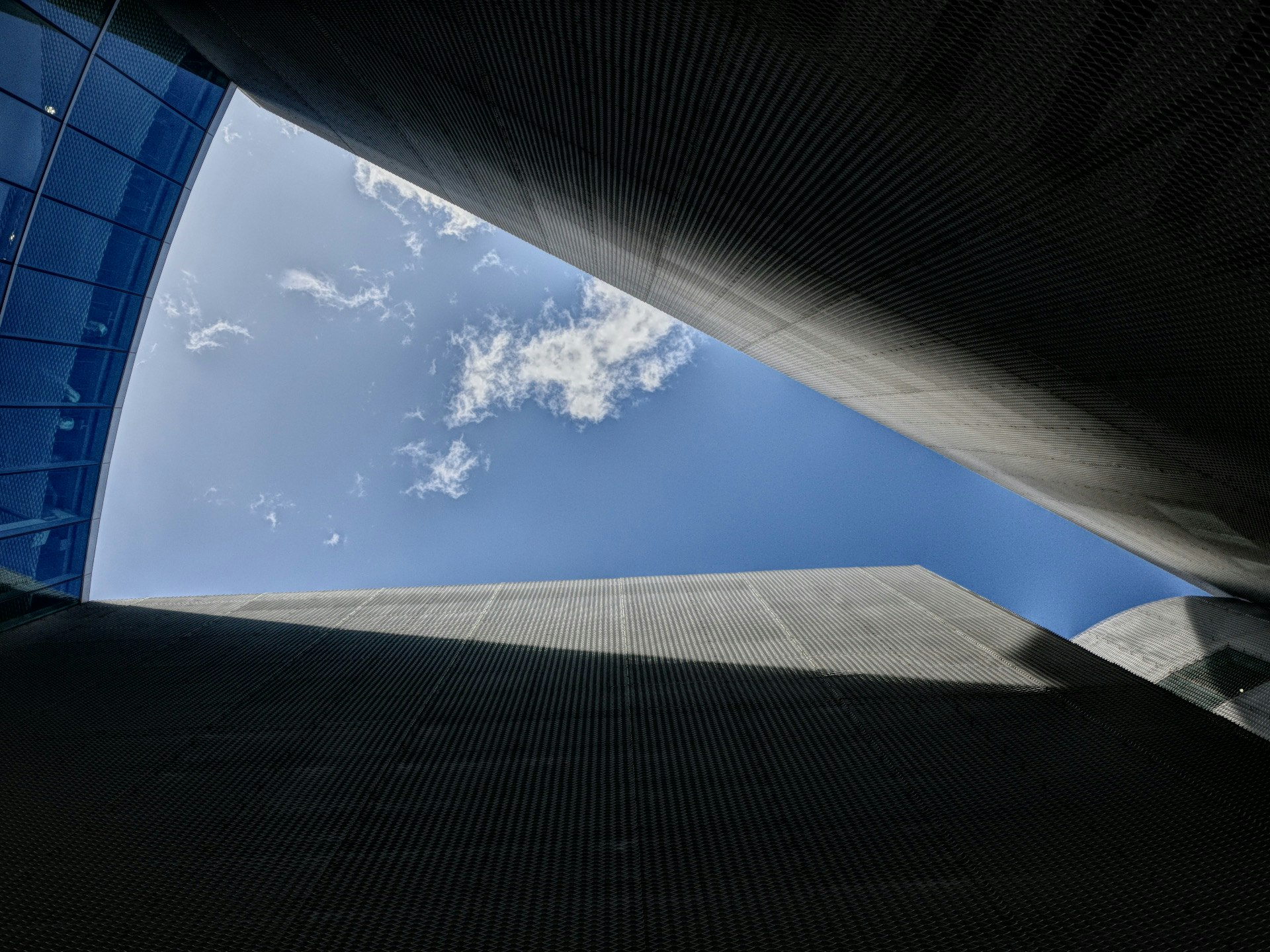 青空を見上げる大きな建築のアーチ状天井と壁面