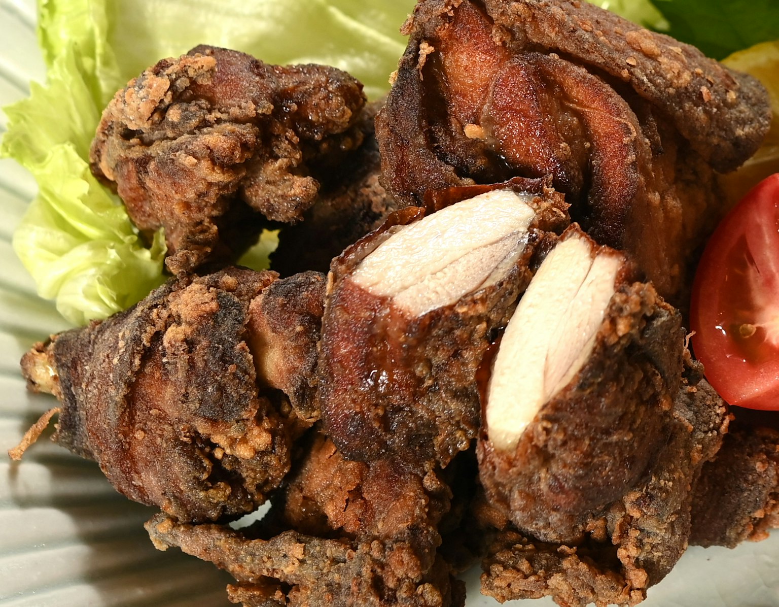Plato de trozos de pollo frito con lechuga y tomate