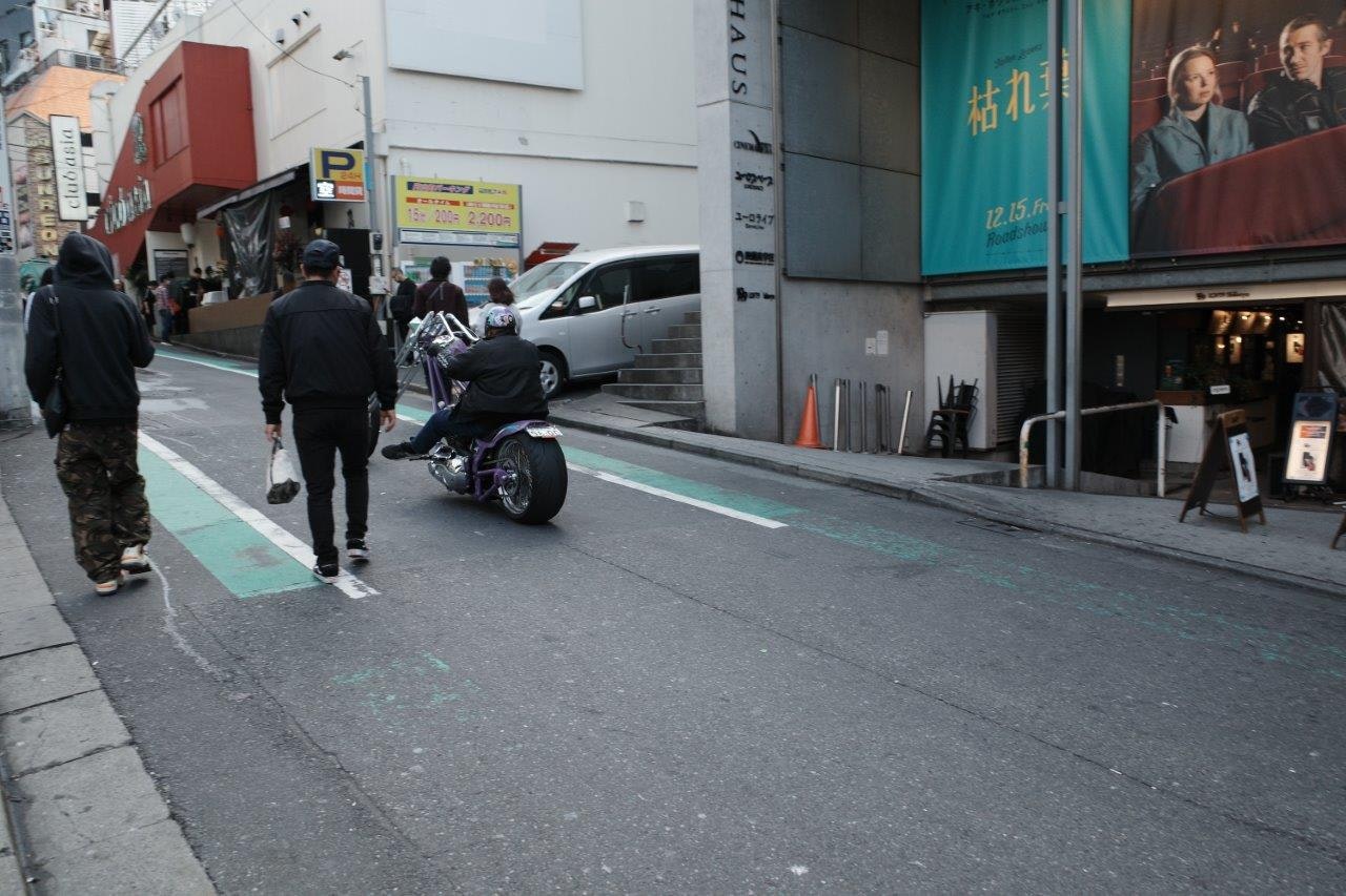 路地のバイクと歩行者が行き交う街角
