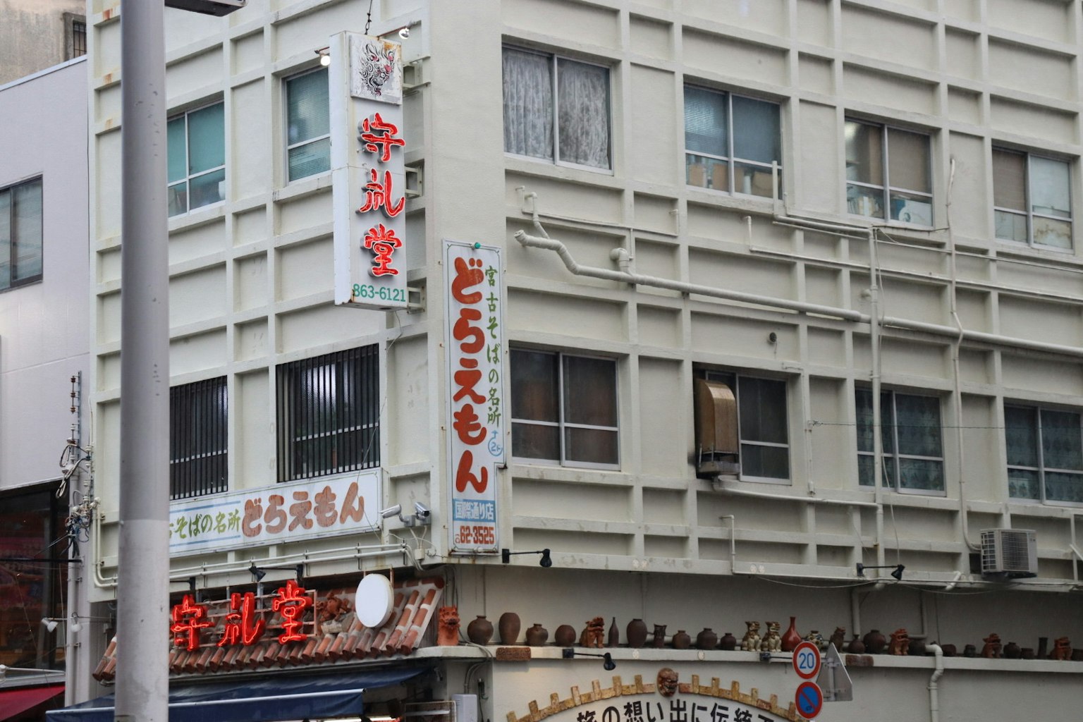 Exterior de un restaurante con letrero japonés en un edificio blanco