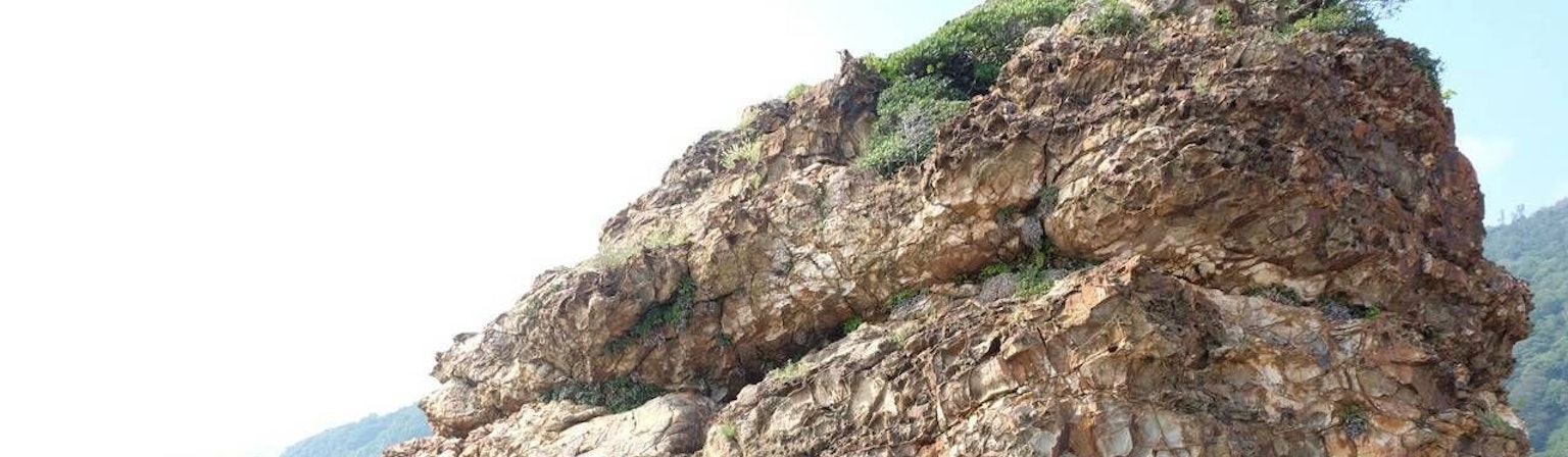 Coastal view featuring a rocky structure with greenery on top