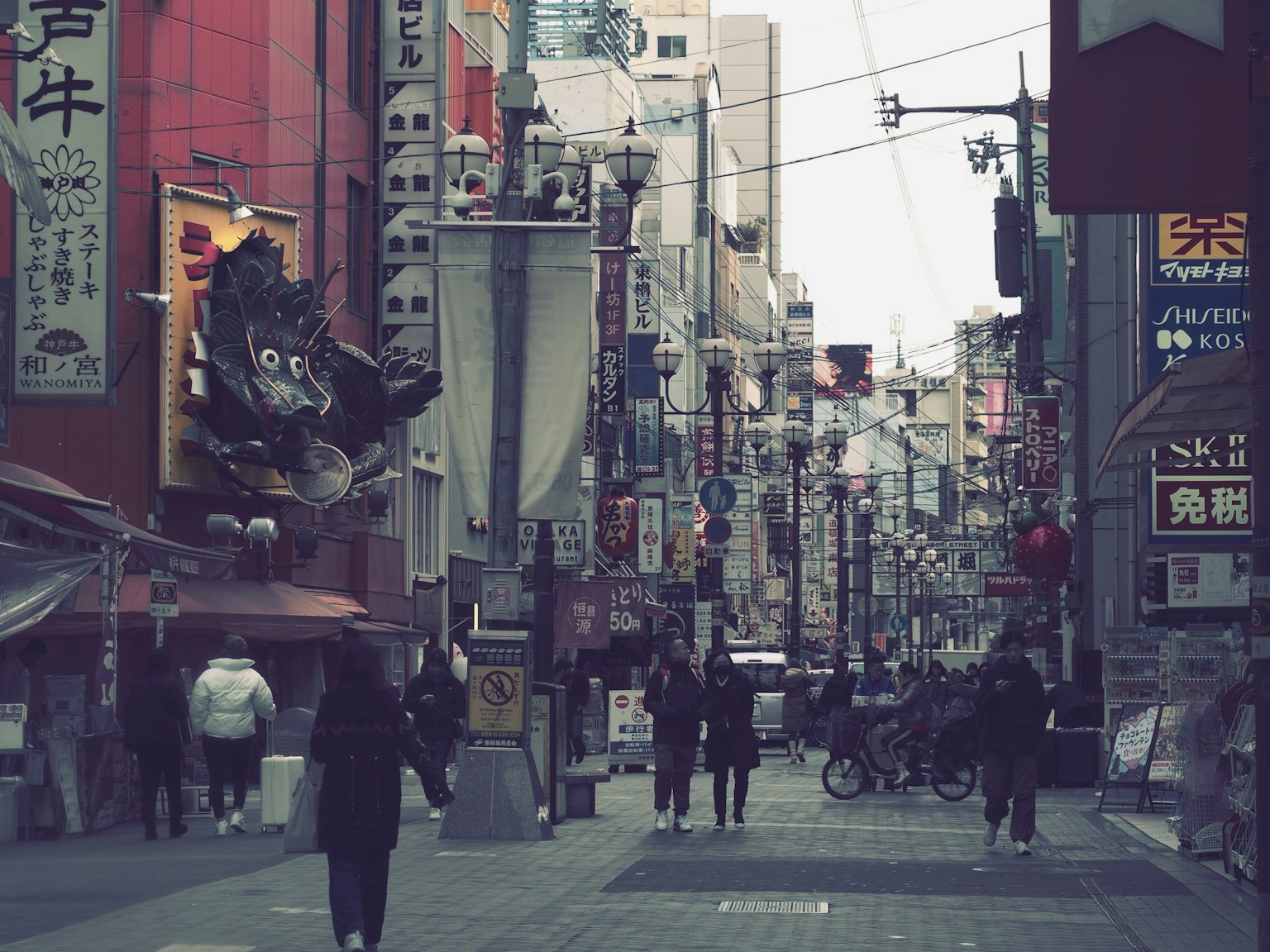 ฉากถนนในเมืองที่คึกคักพร้อมป้ายและผู้คนเดิน