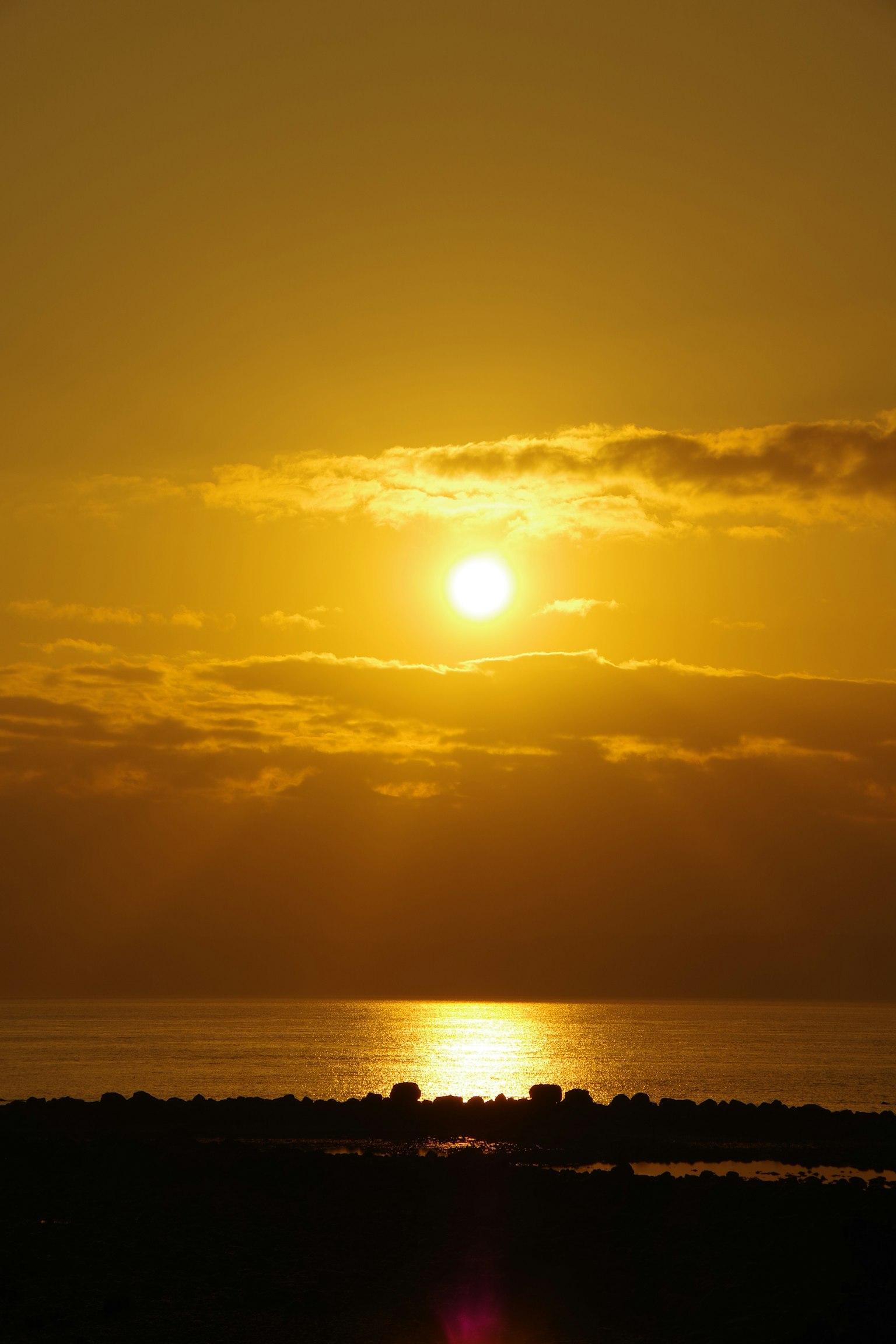 Tramonto sull'oceano che riflette tonalità dorate