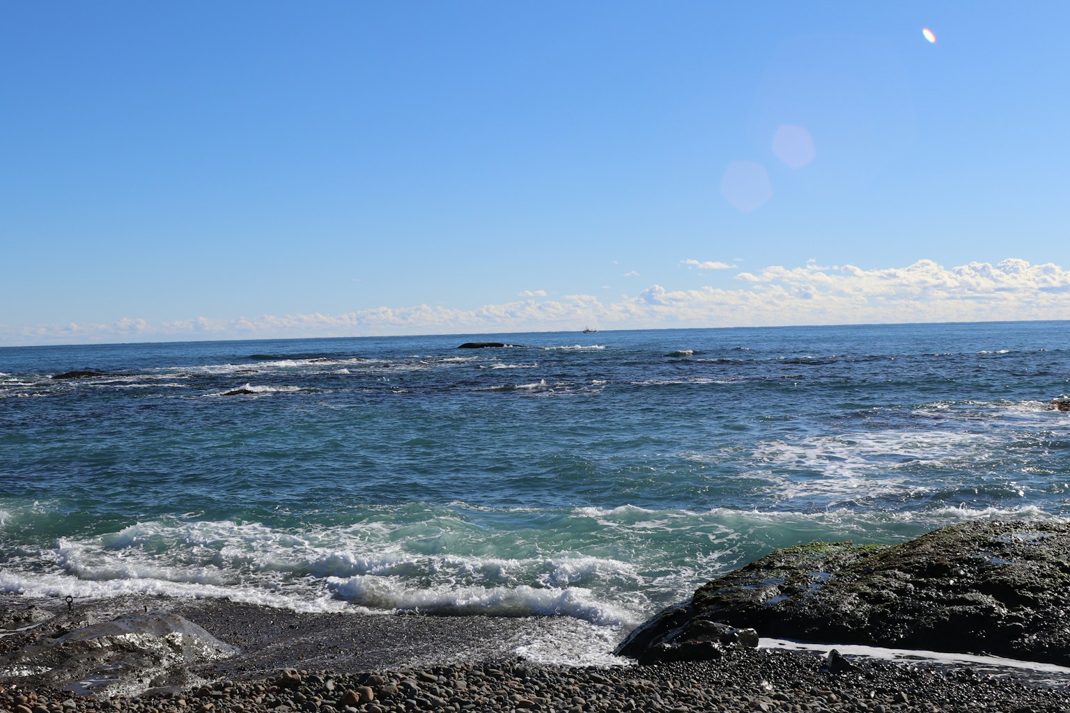 Scenic view of the blue ocean and rocky shore on a clear day