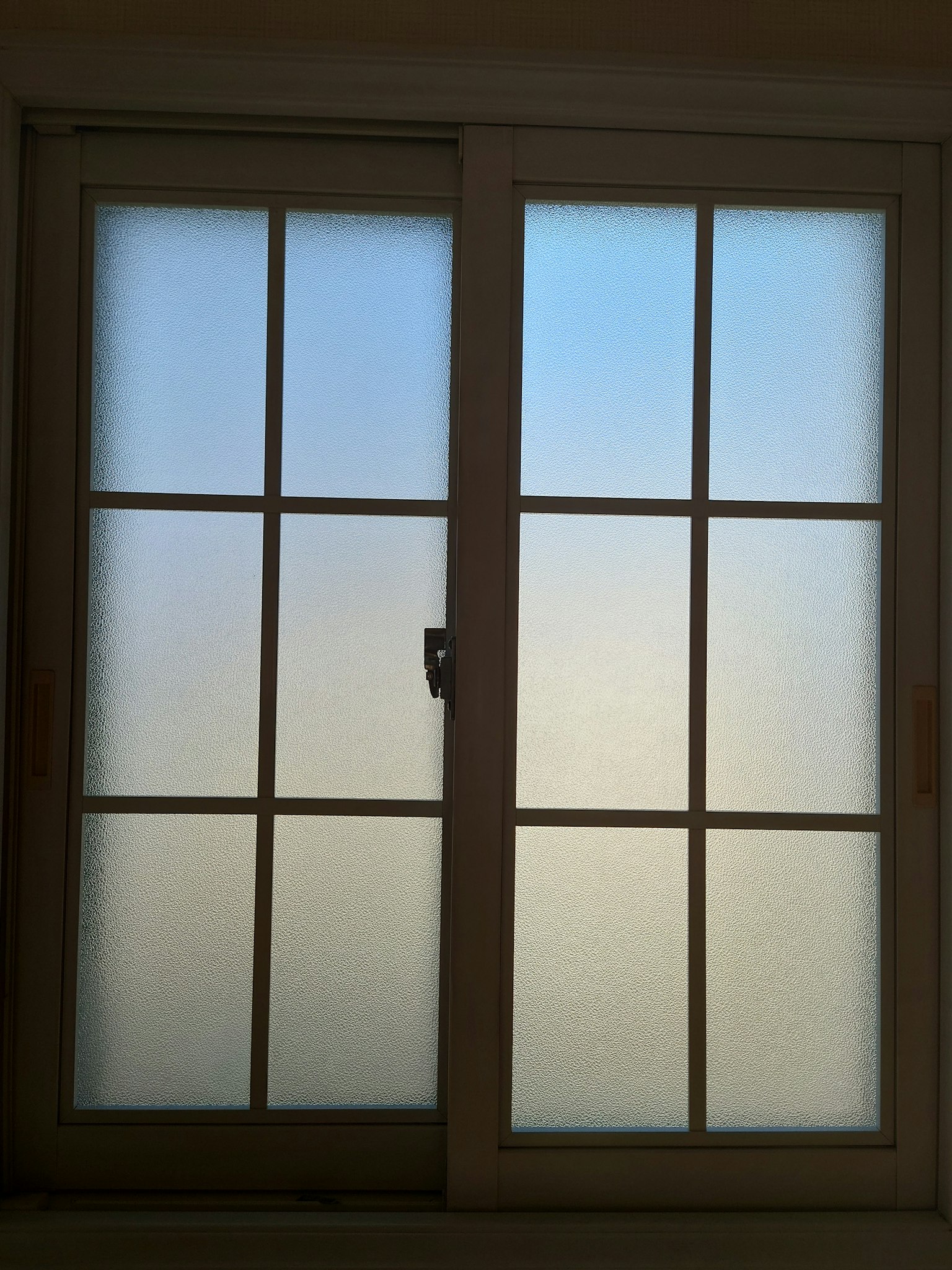 Silueta de una ventana de vidrio esmerilado dejando entrar luz
