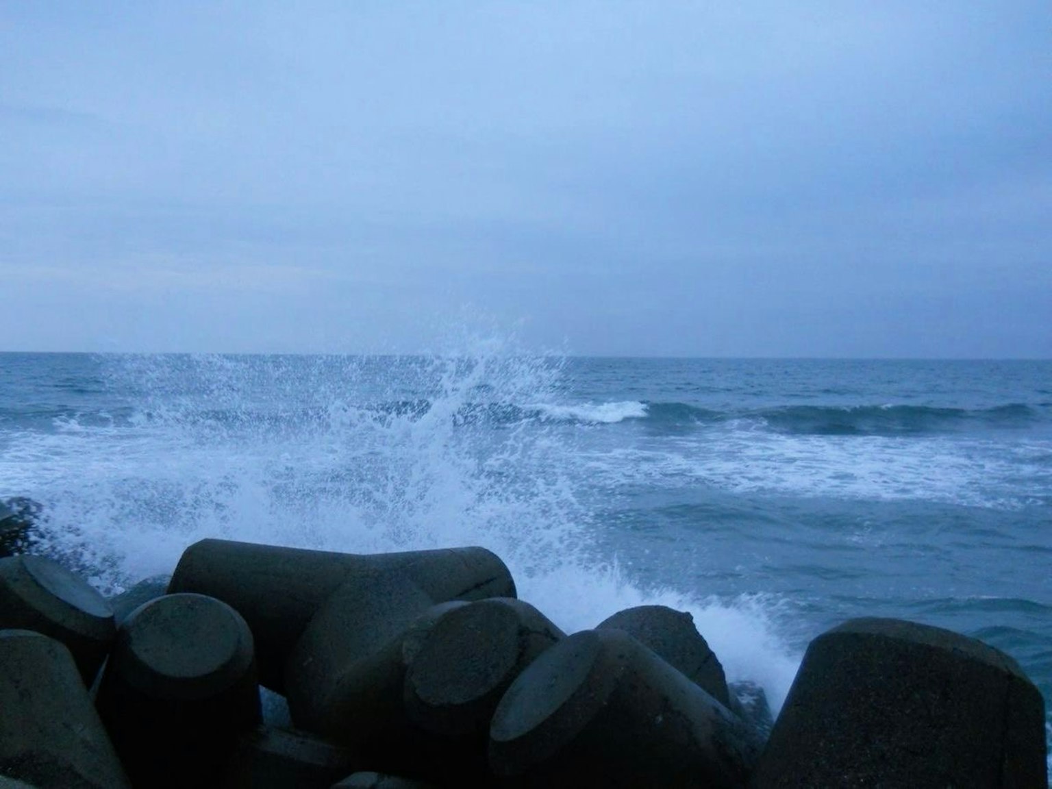 Vagues de l'océan s'écrasant contre des brise-lames en béton