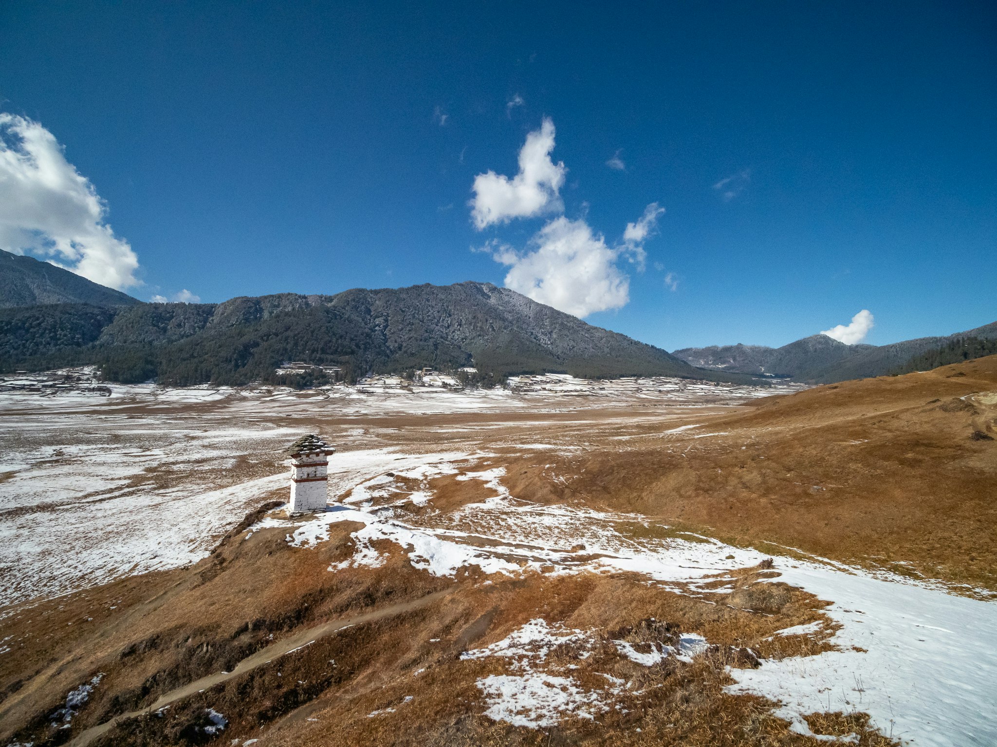 Paisaje de altiplano con parches de nieve y cordillera