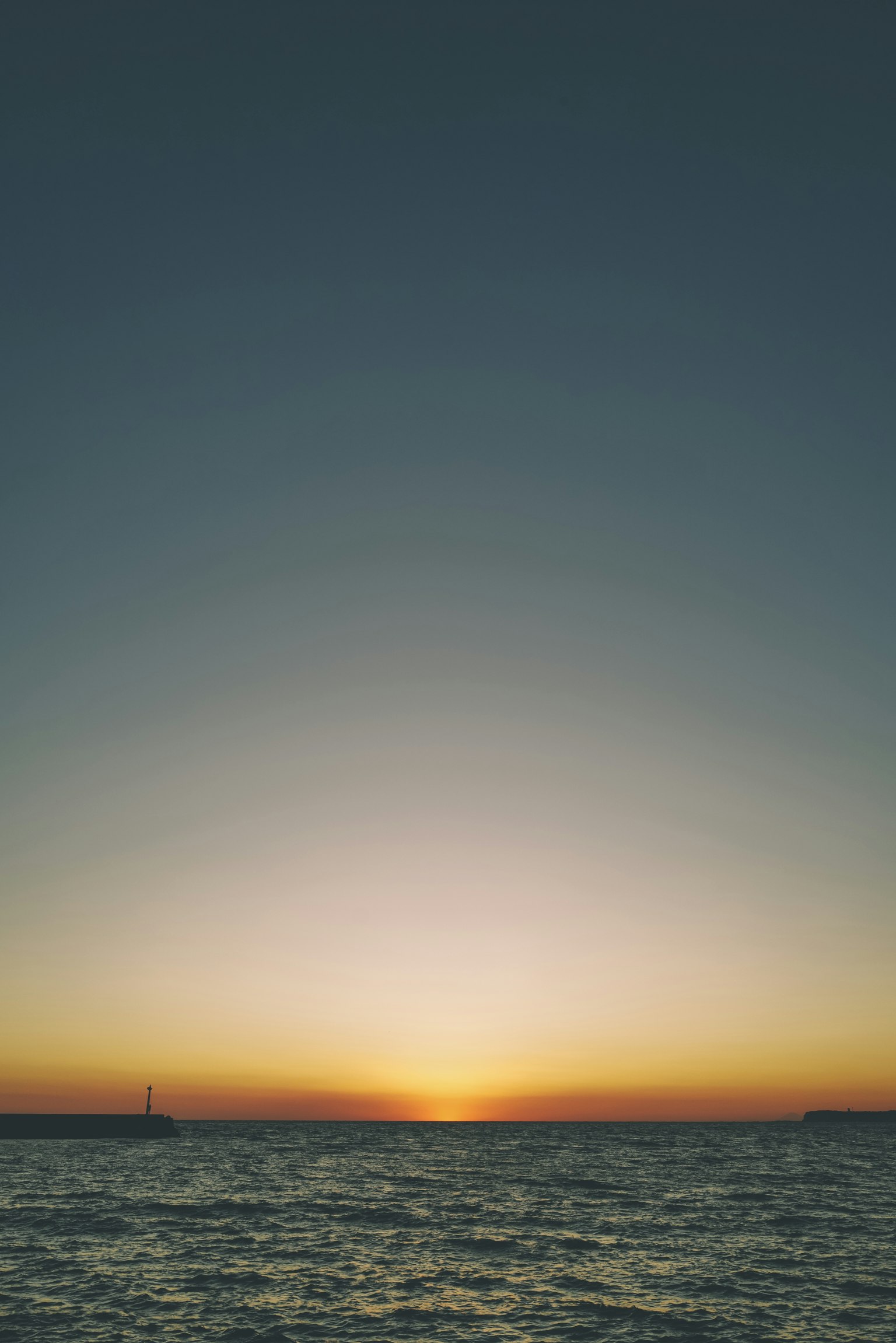 Sonnenuntergang über ruhigem Wasser mit einem Farbverlauf am Himmel