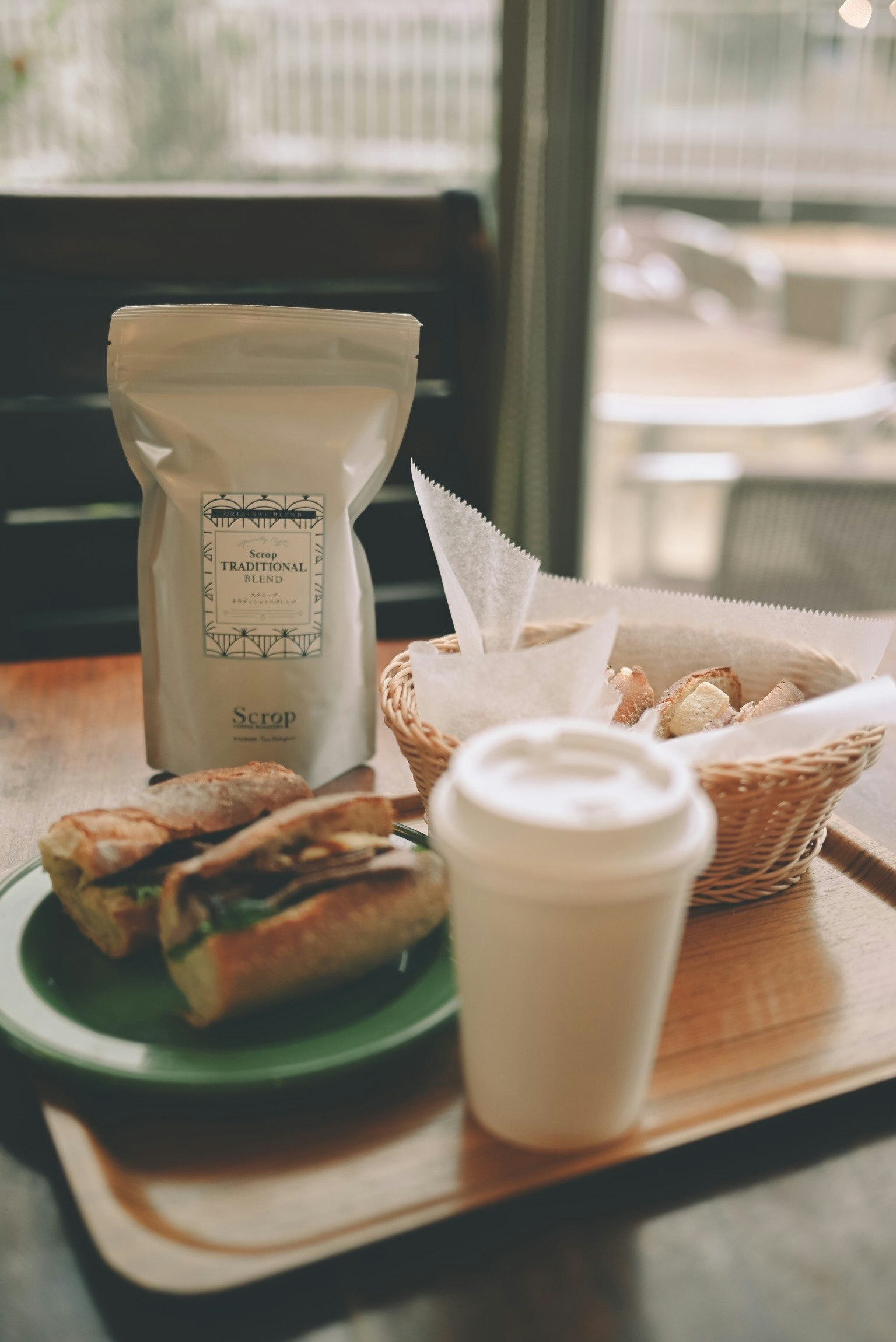 Piring kopi dan sandwich di meja kafe
