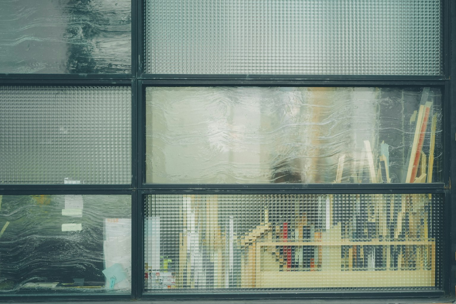 Un espace de travail visible à travers une fenêtre transparente avec des outils et des matériaux en bois