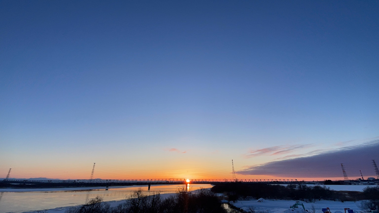 River landscape at sunset with a clear sky and snow