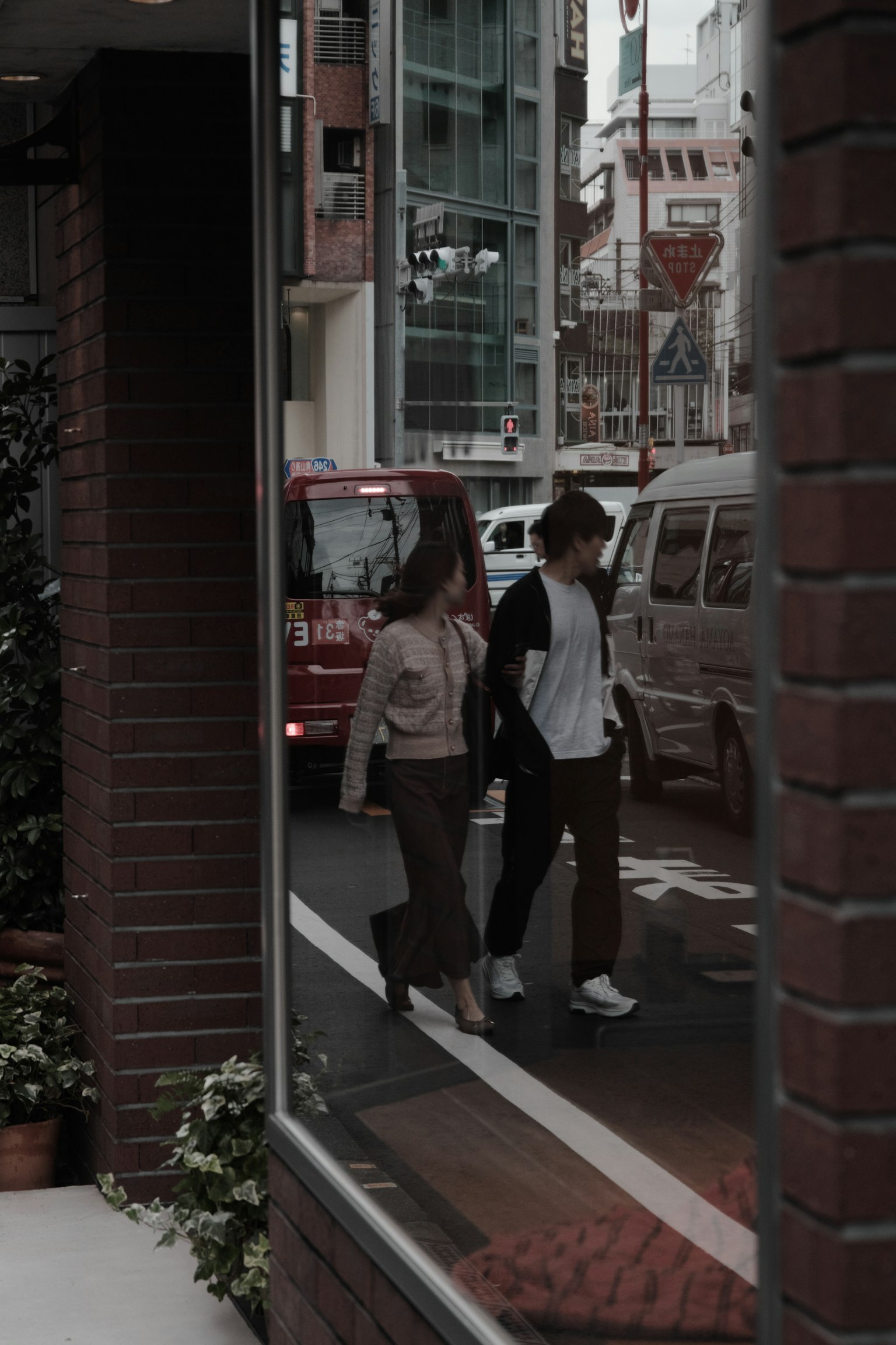 Reflection of a couple crossing the street in a window