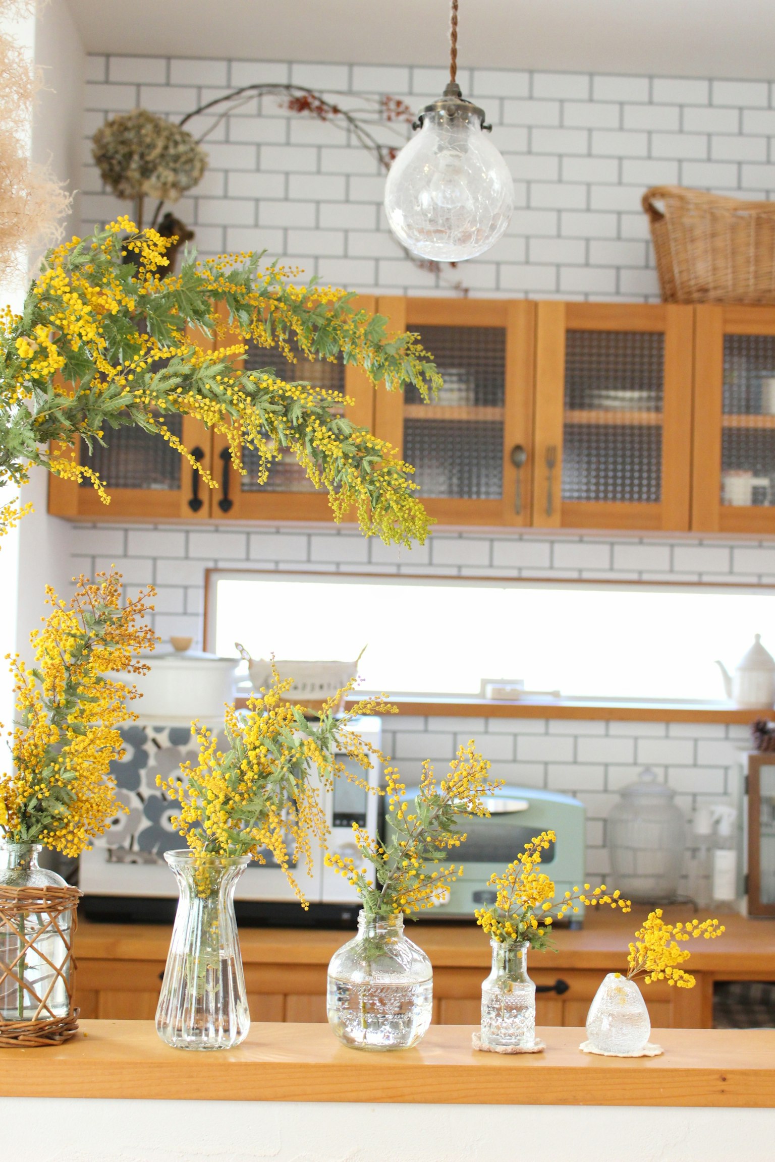Bright kitchen featuring yellow flowers in simple vases