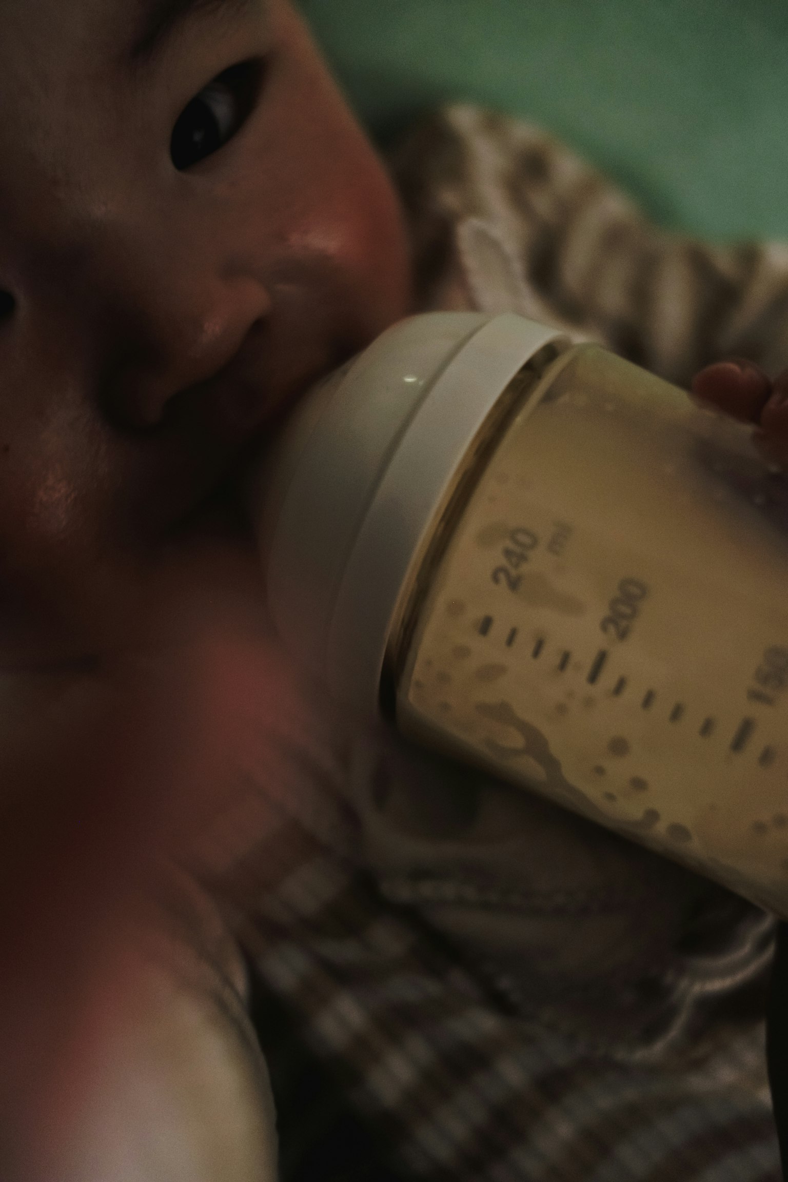 赤ちゃんがミルクボトルを持っている親密なシーン