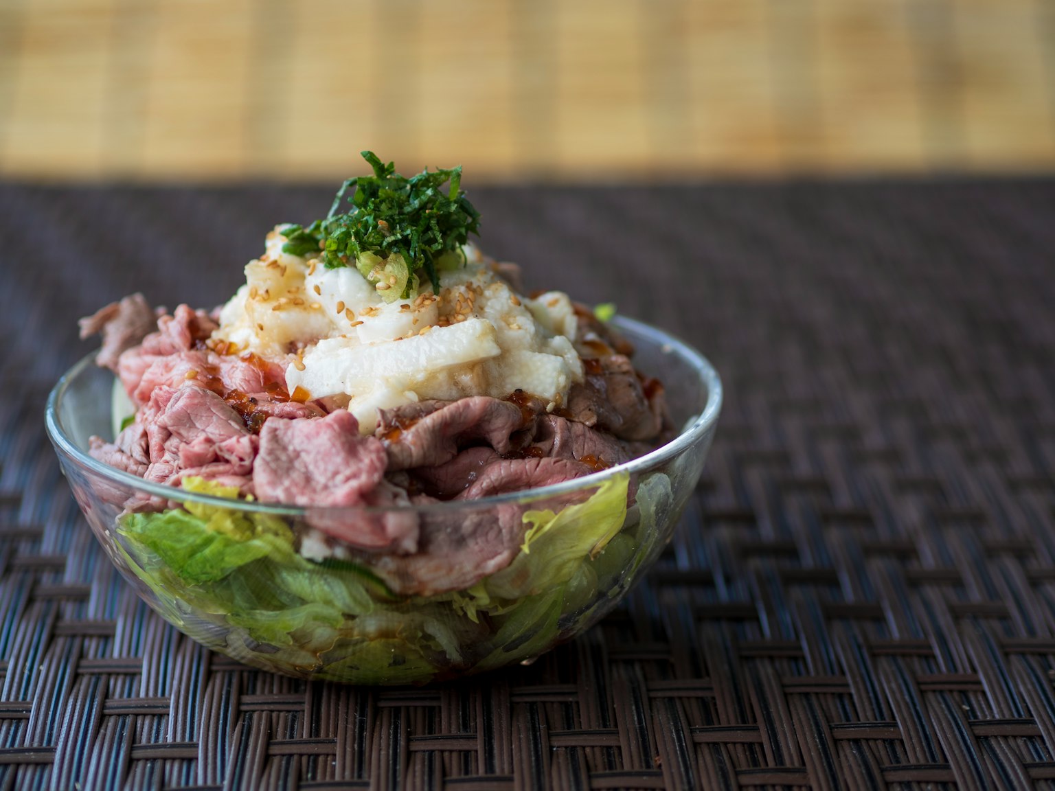 Un tazón de ensalada con lechuga, carne de res y puré de papas