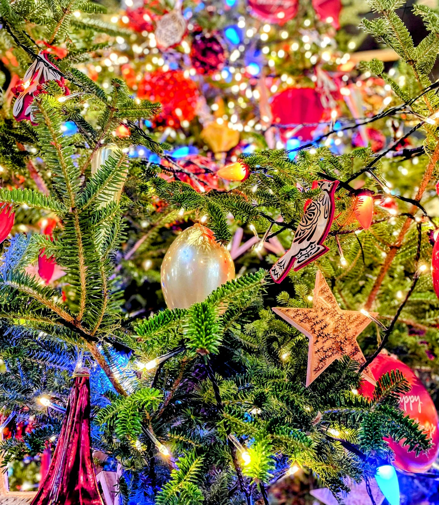 Primo piano di un albero di Natale decorato con ornamenti colorati e luci
