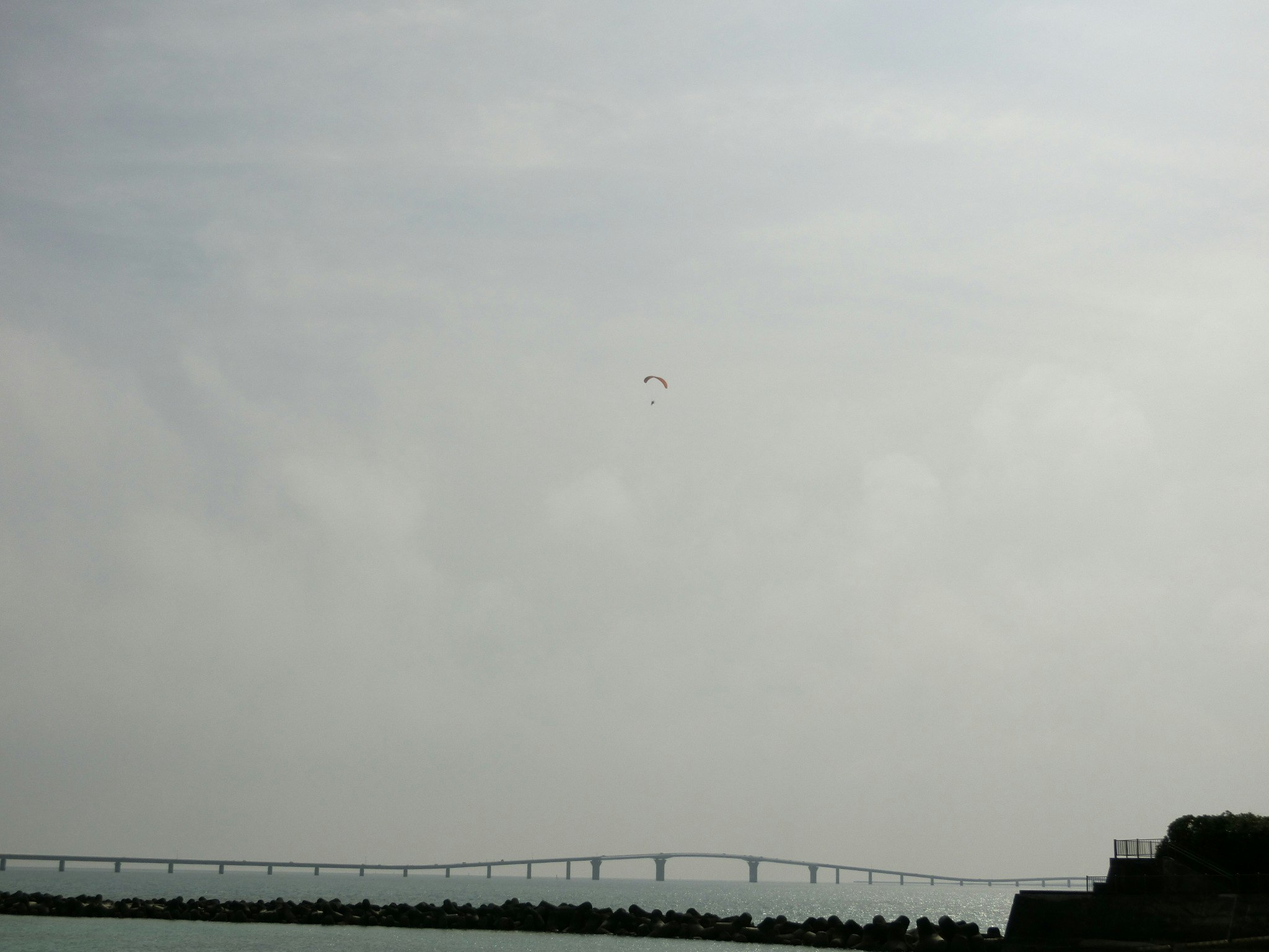 Overcast sky and a distant coastal breakwater line