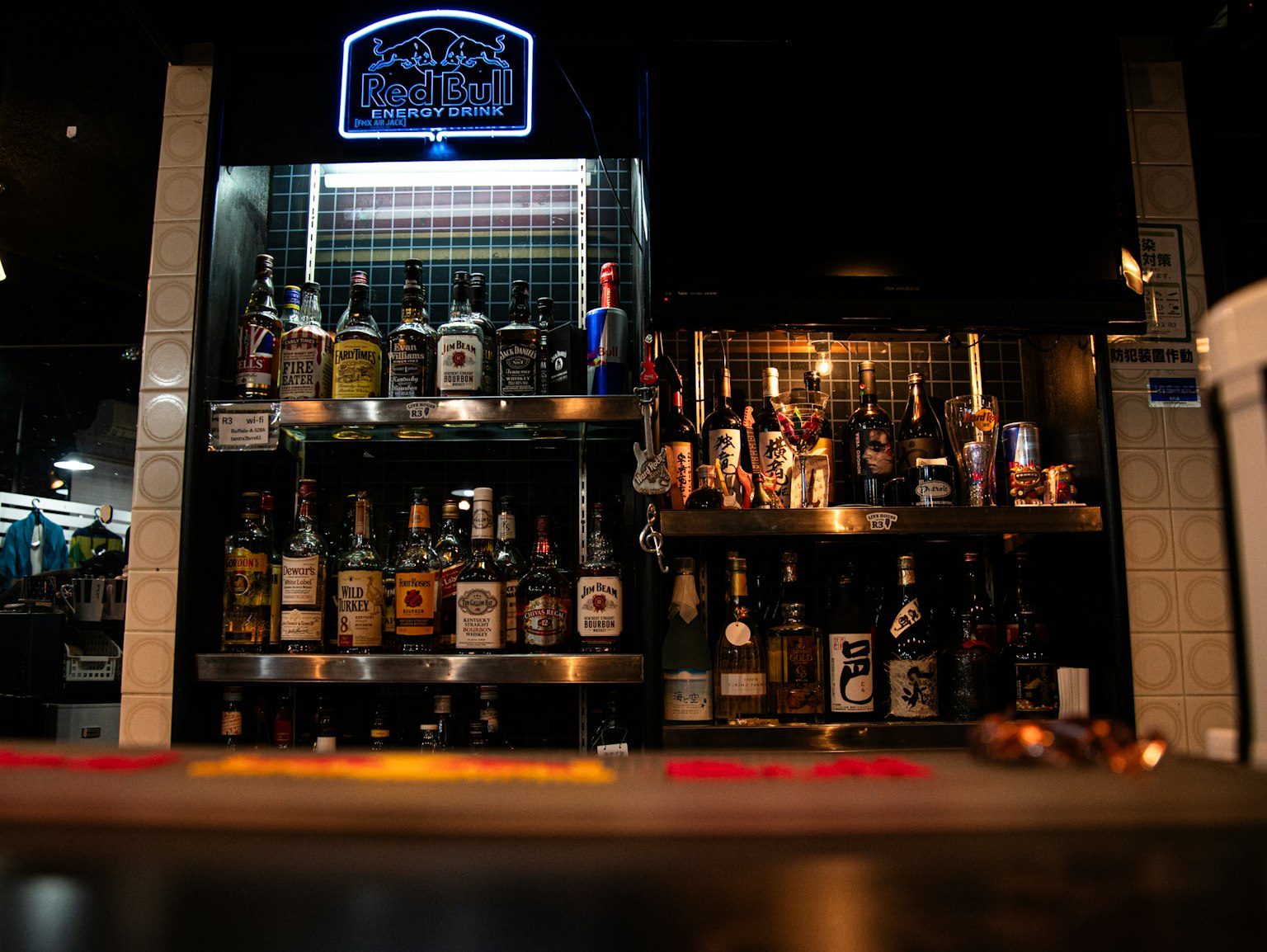 Estantes que exhiben varias botellas de whisky y licor en un bar