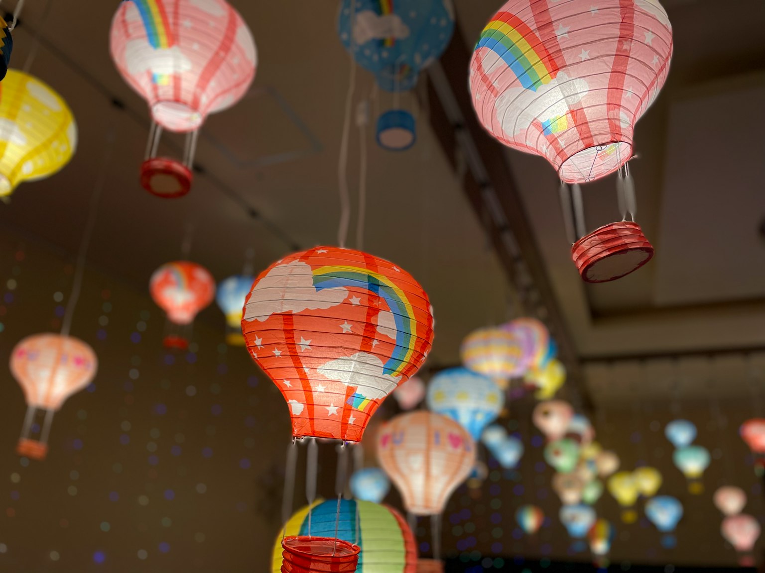 Lampion balon udara berwarna-warni menggantung dari langit-langit