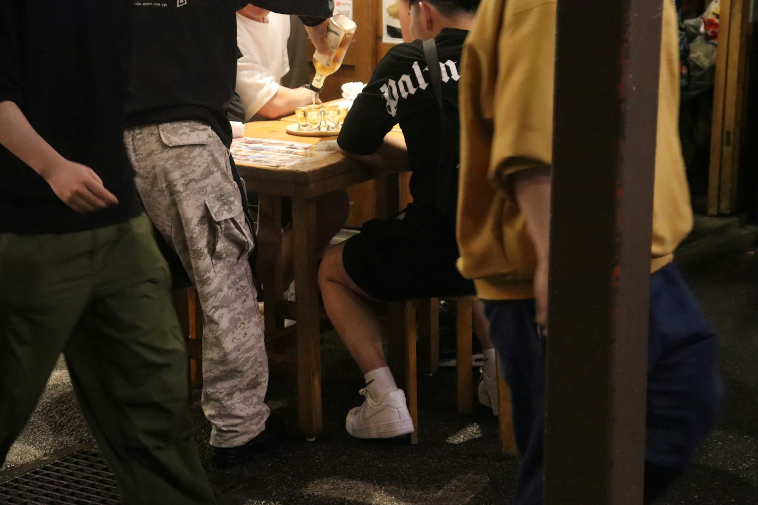 休闲用餐场景，周围桌子上的人们的脚和衣服可见
