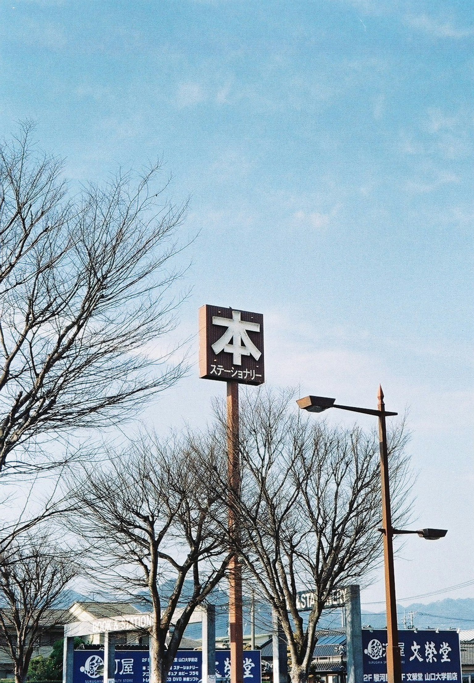 Sign for a bookstore under a blue sky with trees