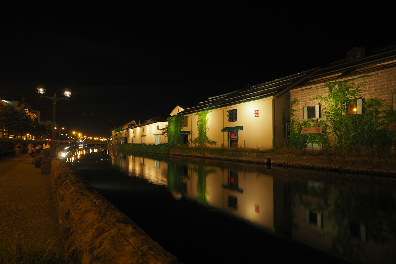 Edificios a lo largo de un canal por la noche con reflejos en el agua