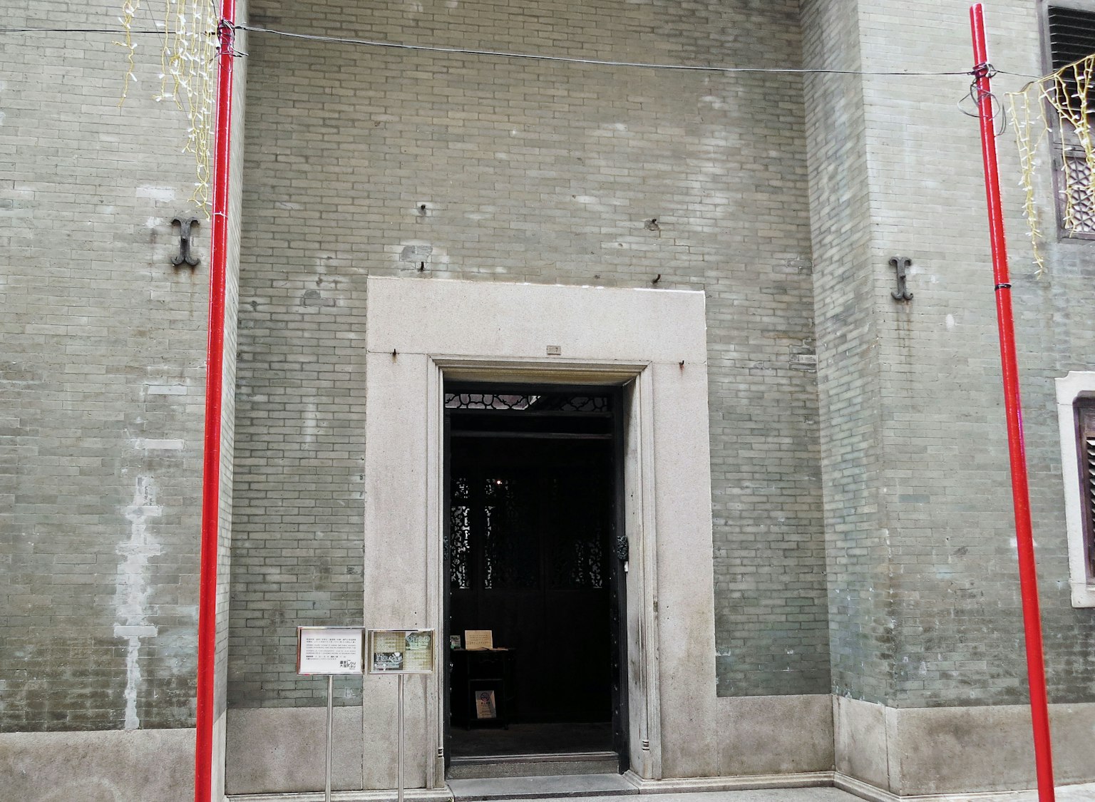 Ingresso di un edificio con pareti verdi e pilastri rossi