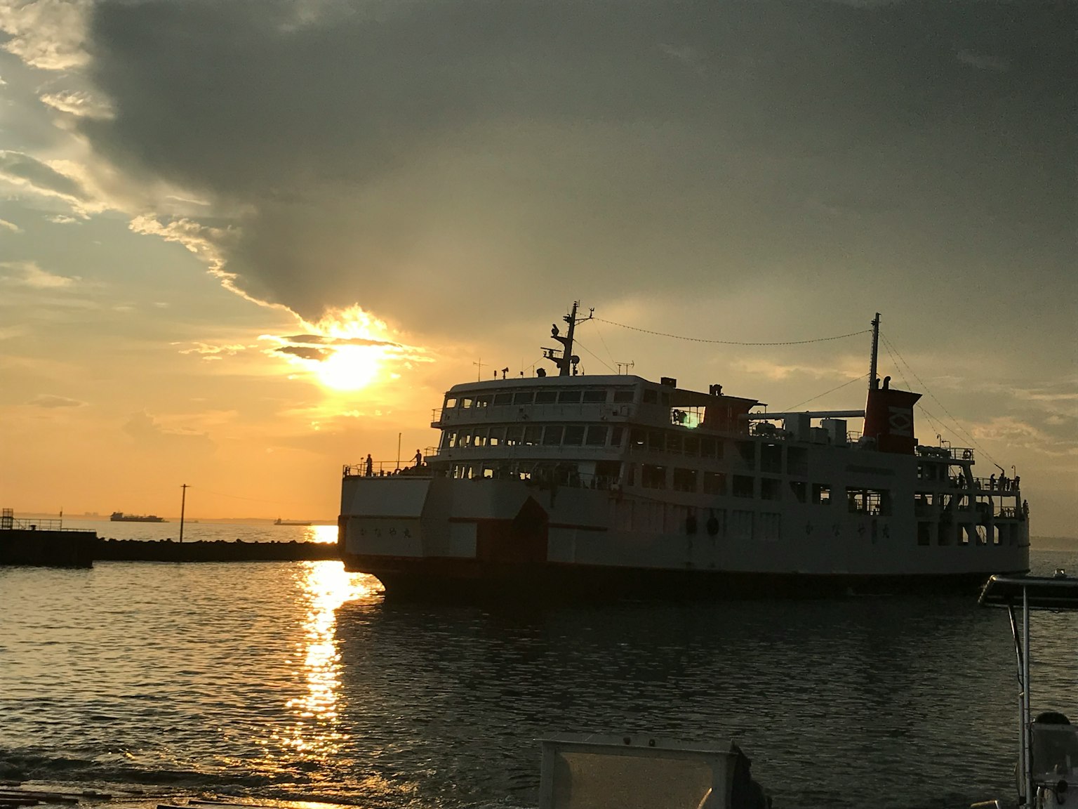 一艘渡輪在平靜海面上的日落輪廓