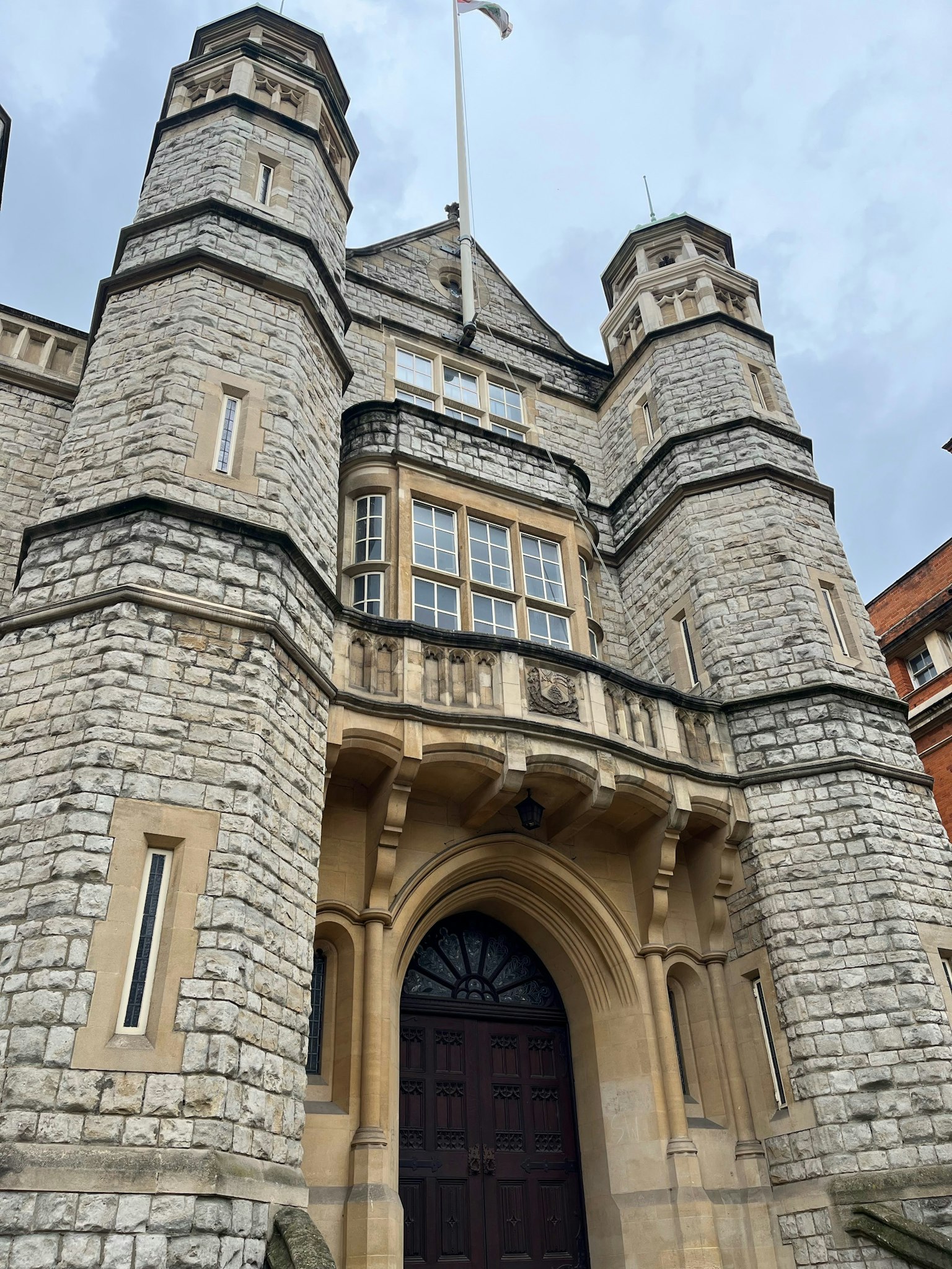 Entrée principale d'un bâtiment en pierre semblable à un château avec des tours