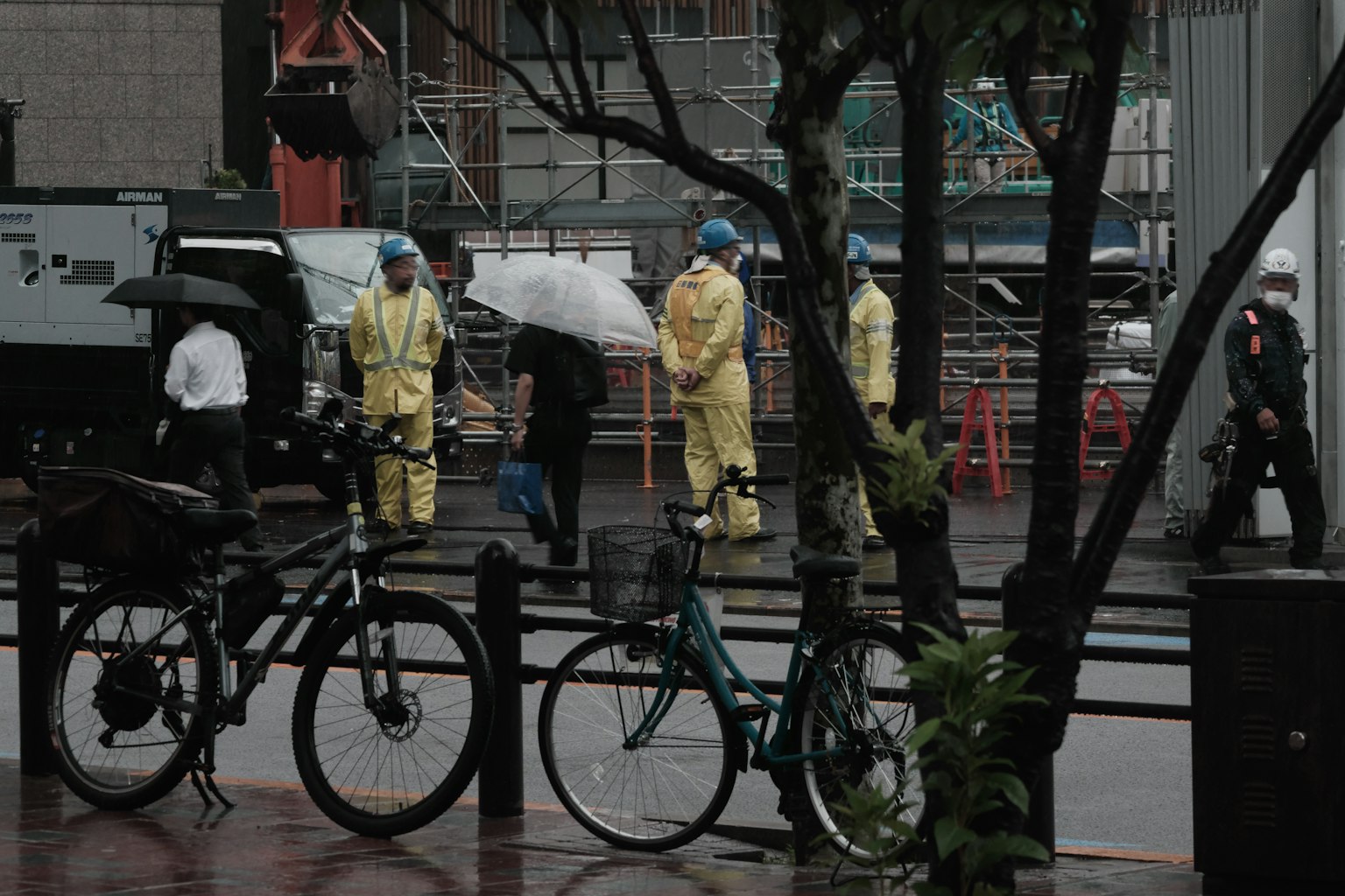 Scena urbana con persone che lavorano sotto la pioggia e biciclette
