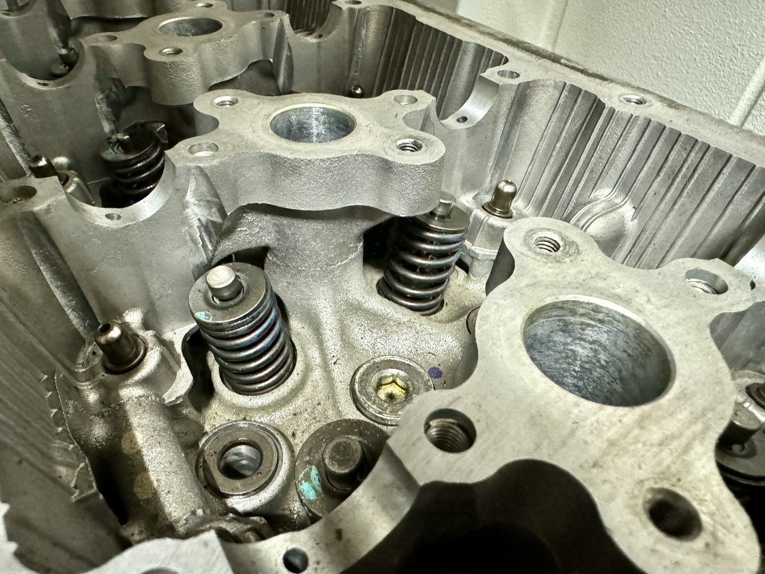 Vista detallada del interior de una culata de motor que muestra los resortes de válvula y componentes metálicos precisos
