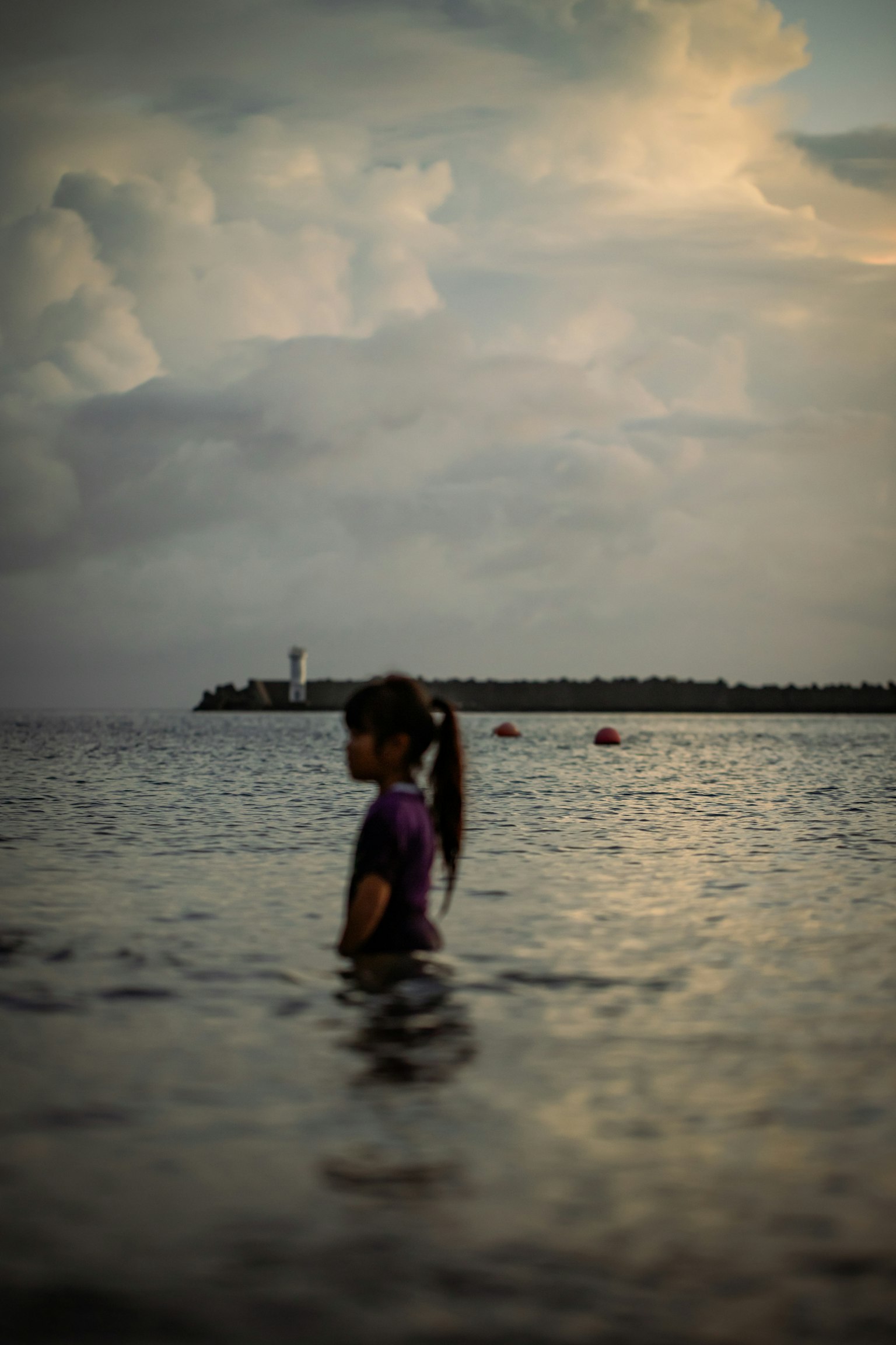 Silhouette di una ragazza che gioca nel mare al tramonto