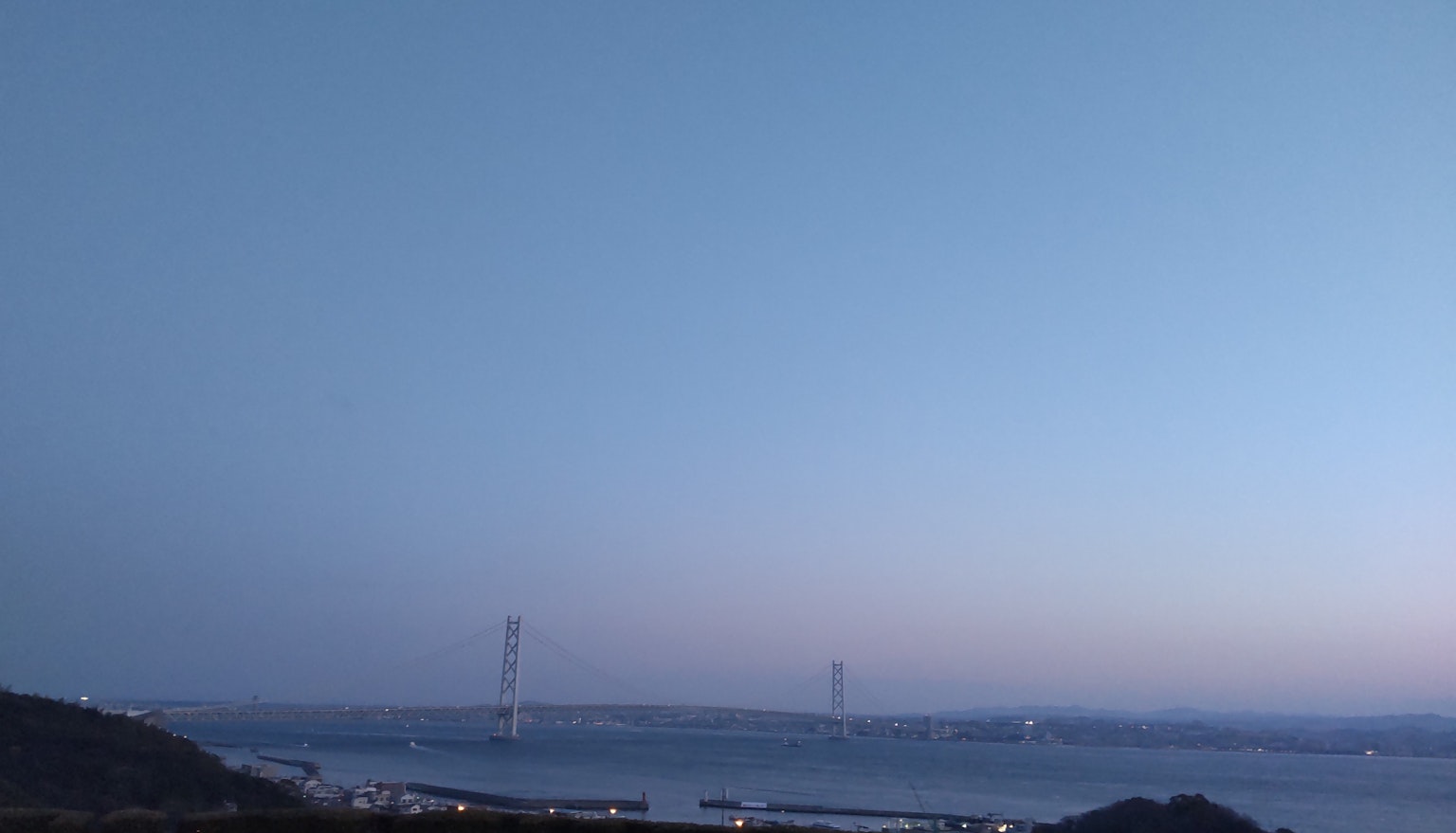 Silhouette of a bridge over the sea during twilight