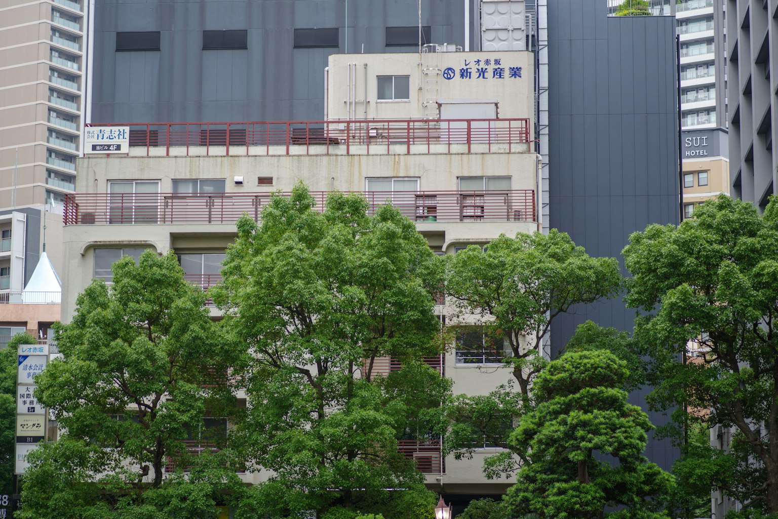 城市景观中有一栋建筑和对比鲜明的绿色树木