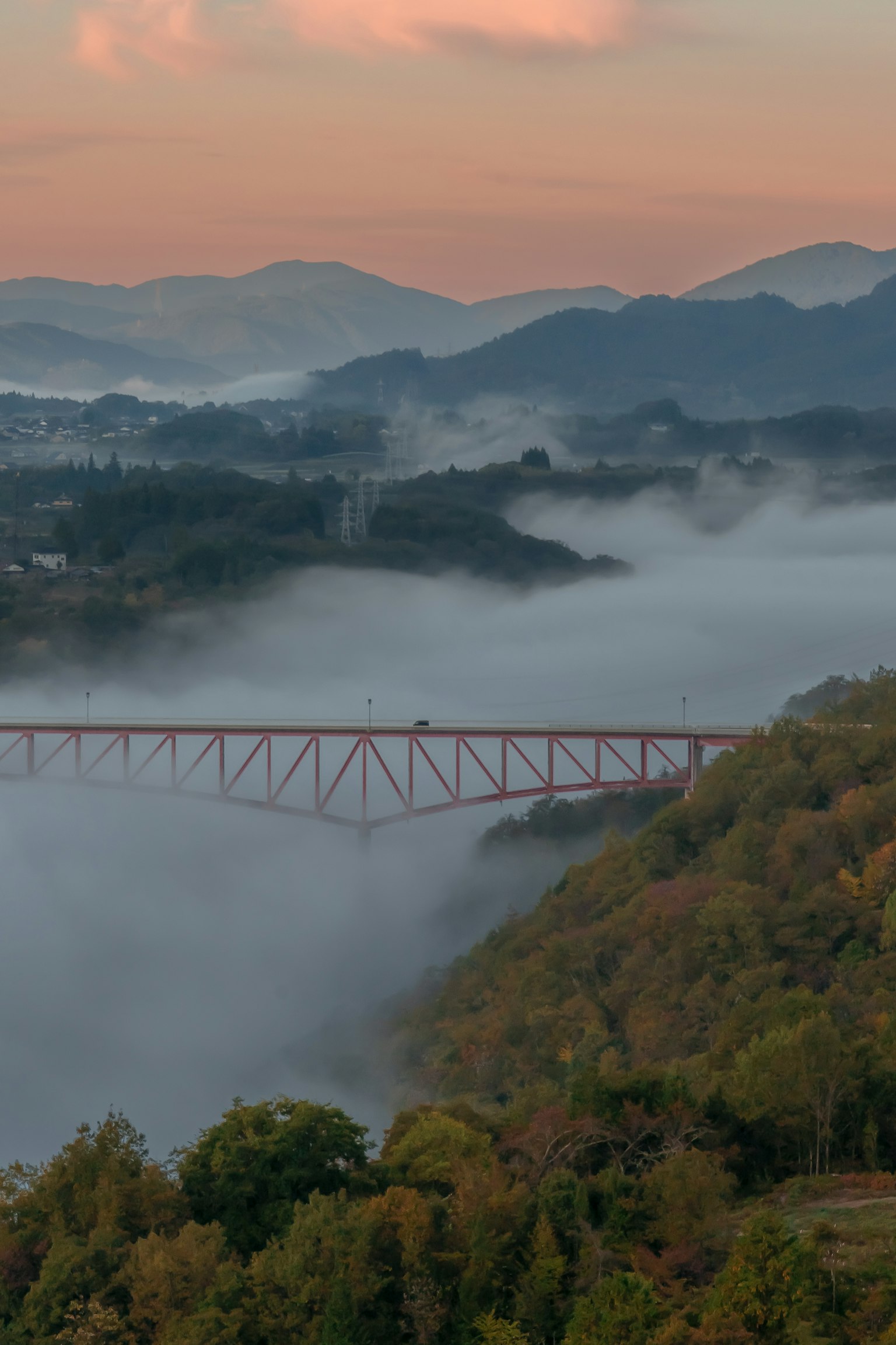 Pemandangan jembatan yang dikelilingi kabut dan gunung