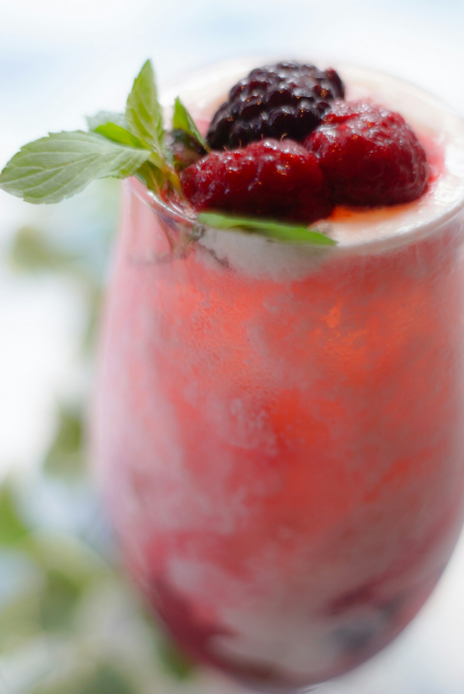 A refreshing fruit cocktail glass topped with raspberries and blackberries