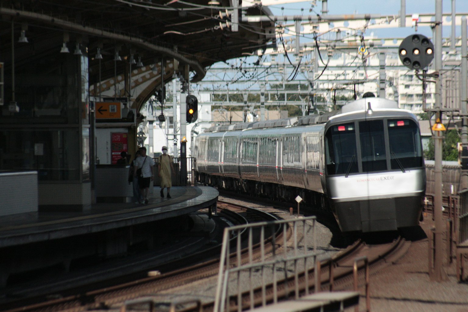 Train naviguant dans un virage à une gare avec des feux de signalisation