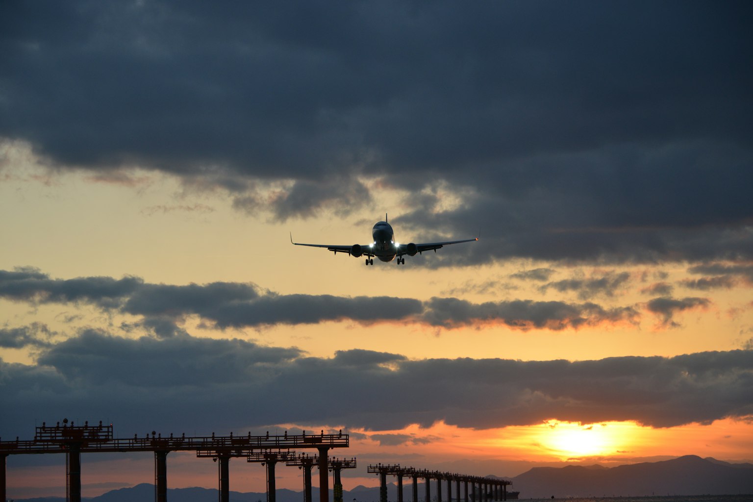 Airplane landing against a sunset sky